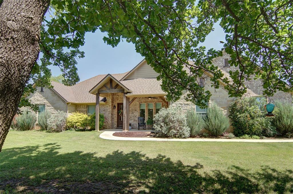 Beautiful brick and stone home in Peaster ISD sits on 3+ acres providing lots of open space. With 4 bedrooms, 2.1 bathrooms, an in-ground swimming pool, beautifully landscaped yard with irrigation system, a great barn and a round pen, there is something to delight everyone. The spacious living area has soaring ceilings and a wall of windows for lots of natural light and a view of the lush backyard and pool. A large stone, wood-burning fireplace with gas starter completes the living area. The kitchen has a large island, stainless appliances decorative lighting, a walk-in pantry, and lots of storage. The 2.5 car garage has a temperature controlled room for storage or workshop area. The like-new barn with electricity and water has 3 large covered stalls with an automatic waterer in each stall, a concrete alley-way, a tack room, a hobby room or workshop, and plenty of room for hay storage. The property also has a chicken coop with 6 laying boxes, and a fenced run with animal proofing to protect your flock. The property is fenced and cross fenced with most fencing being pipe and no-climb wire. A must see!  *Buyer to assume remaining portion of lien on attached Road Improvement Assessment*