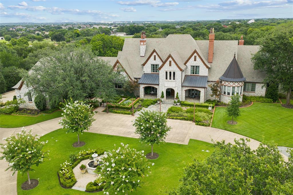 French country elegance meets Texas charm on 7.7 fully fenced acres in coveted Northwest Colleyville. This 9,600 SF estate offers 7 living areas, 5 bedrooms, 7 baths, and endless amenities designed for both everyday living and grand entertaining. Inside you’ll find soaring ceilings, hand-carved fireplaces, Gracie hand-painted wallpaper, a chef’s kitchen with dual islands open to the breakfast area & oversize family room. The game room with onyx wet bar overlooks the backyard living. A catering scullery provides prep and cook space for entertaining large groups.  The media room is perfect for private viewings. The formal living and dining rooms both open to a covered front terrace. The private executive office is fully paneled in mahogany. The primary suite is its own  retreat with dual en-suite baths, custom 3 level closet, a private sitting room, safe room, and stunning views of the grounds.  Out back you'll find resort-style living including a pool with beach entry, glass-walled pool house with a full kitchen and 2 luxury baths, outdoor kitchen, firepit, and putting green. Additional highlights include a 4-car garage with one bay climate-controlled and currently used as a dog room, gorgeous glass Hartley Botanic greenhouse, and very secure chicken coop. Updated systems throughout ensure comfort and peace of mind.  There is an additional garage-shop-service building with 5 auto bays, space for RVs and an efficiency apartment. Wells on the property are for landscape use.  This is a rare blend of sophistication, privacy, and luxury living in one of Colleyville’s most desirable areas.