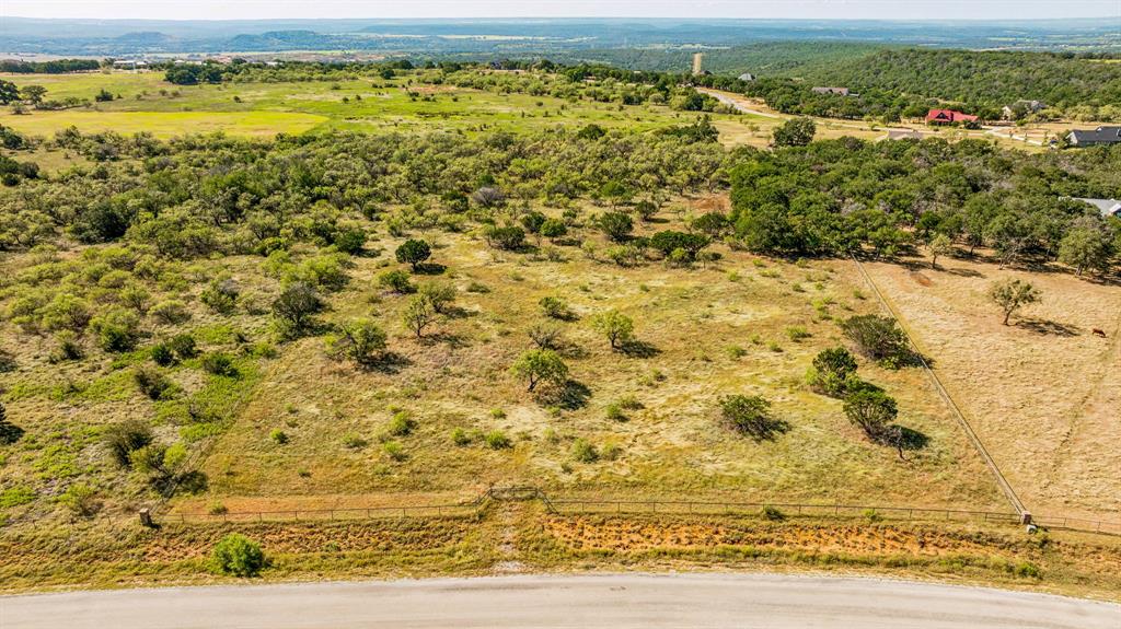 Located in 7-R Ranch in Gordon Texas sits this 4.85-acre tract with stunning views. Perfect for building the home of your dreams in an exclusive gated community. Tucked away with beautiful scenery, fully fenced with pipe and smooth wire. This is your chance to own a quiet & cozy retreat. 7-R Ranch has amazing on-site facilities that cater to every need, workout equipment, aerobics loft, indoor lap pool, steam room, hot tub, game tables, movie theater, huge pool, sand volleyball, & horseshoes. The Cove on Lake McIntire includes a clubhouse on the shores of Lake McIntire with pool, fishing pier, boats, & kitchen. The Eagles Nest is a trailhead connecting to the 260-acre Canyon Lake Nature Park with trails & fishing lakes. The Joe Watts Stable offers guided horseback rides and private boarding. This property has so much to offer, come take a look today!