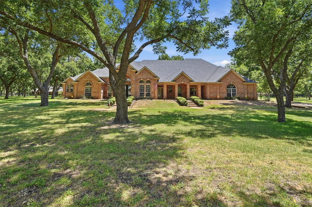 Nestled on 2.65 breathtaking acres shaded by 63 mature pecan trees, this custom 4,000+ square foot estate offers a rare opportunity to own a private retreat within the prestigious gated community of Pecan Plantation. Tucked away on a quiet cul-de-sac in The Retreat, this property creates a park-like setting where deer, native birds, and abundant wildlife can be enjoyed from multiple covered porches, expansive windows, and the backyard oasis.
Designed for both everyday living and entertaining, the thoughtfully planned layout features five bedrooms with a desirable split-bedroom arrangement, soaring ceilings, two inviting fireplaces, and a timeless blend of hardwood flooring, tile, and carpet. The spacious kitchen is equipped with granite countertops, stainless steel appliances, extensive cabinetry, built-in storage, and generous prep space. The versatile upstairs bedroom also serves perfectly as a game room, media room, or private guest suite, while multiple living areas provide flexibility for gatherings of any size. Outside, the sparkling swimming pool offers the perfect place to relax, surrounded by mature trees and peaceful natural beauty. Additional highlights include a sprinkler system and exceptional storage throughout.
Pecan Plantation offers an unmatched lifestyle with two championship golf courses, two private airparks, tennis and pickleball courts, equestrian facilities, a marina on Lake Granbury, parks, walking trails, and endless recreational opportunities. The Brazos River is just moments away, offering fishing, kayaking, and outdoor adventure.
Located just minutes from Historic Granbury's vibrant downtown square with boutique shopping, dining, entertainment, and year-round events, this remarkable property combines the tranquility of country living with modern convenience. With the Dallas-Fort Worth Metroplex less than an hour away, this exceptional estate offers luxury living surrounded by nature in one of North Texas' most sought-after communities.