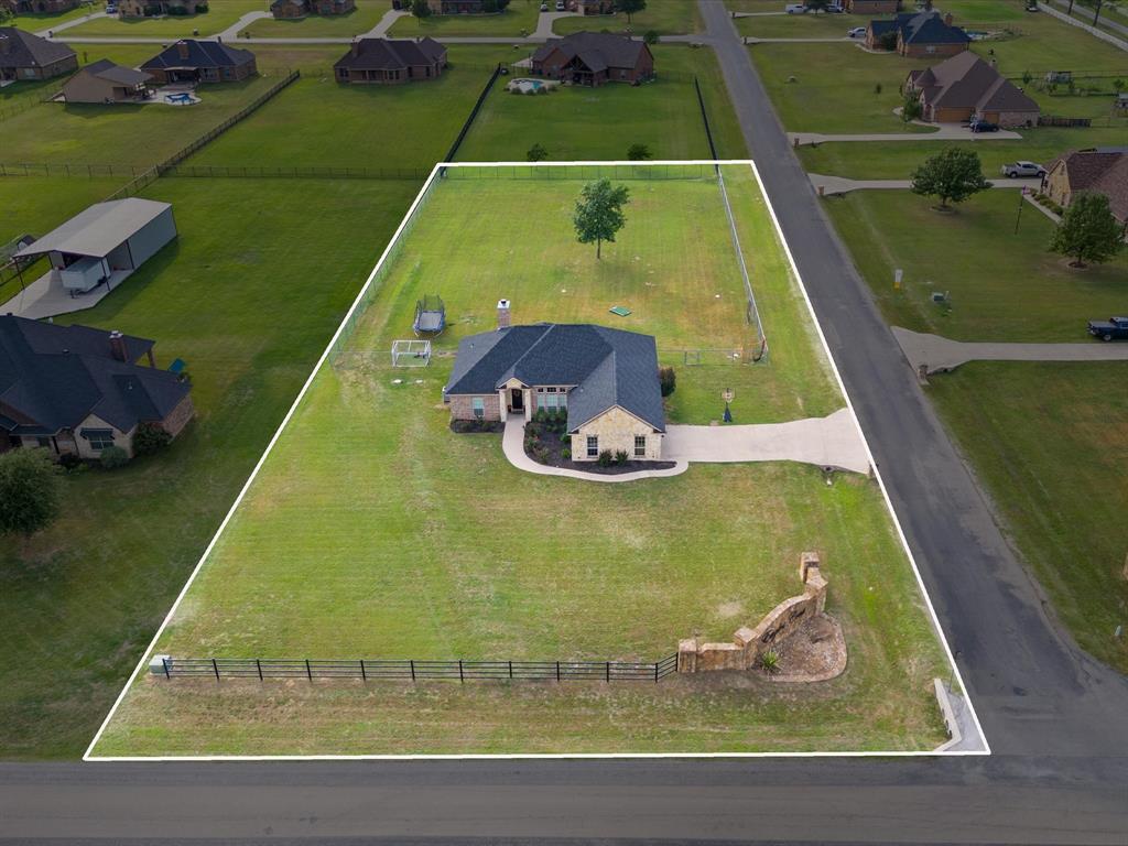 Perfectly situated on a spacious 1-acre corner lot in BROCK ISD, this beautifully maintained single-story home offers the perfect blend of peaceful country living and everyday convenience with easy highway access. NEW ROOF, Spring 2024. Situated on a large corner lot as you enter Eagles Crest Estates, while the open-concept with split-bedroom layout provides functionality and comfort. Inside, the central living room is filled with natural light from an abundance of windows and recessed lighting, all centered around a stunning stone wood-burning fireplace with built-in shelving. The front dining space flows seamlessly into the main living area, creating an inviting atmosphere for gatherings and daily living. HVAC REPLACED, 2025. The kitchen features granite countertops, stainless steel appliances, a pantry, and an adjoining breakfast room with picturesque backyard views—the perfect spot to enjoy your morning coffee and sunrise. The spacious primary suite offers a private retreat complete with dual sinks, a soaking tub, separate shower, and his-and-hers closets. Tall ceilings and neutral tones enhance the secondary bedrooms, while NO CARPET anywhere adds style and easy maintenance. Step outside to the cozy covered back porch overlooking the expansive fenced and level backyard, offering endless possibilities for play, entertaining, or creating the backyard oasis of your dreams.  NEW SEPTIC PUMP, 2026. Build your dream shop on one of the more affordable acre lot opportunities in the district!