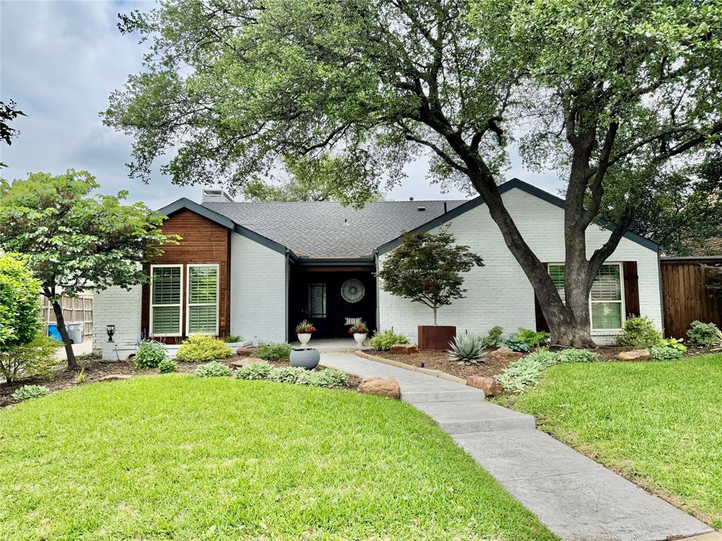 Charming updated North Dallas Home in a quiet peaceful neighborhood.  Enter to an entire home of recently installed engineered hardwood floors.  Beautiful living room w soaring ceilings, gorgeous decorative remote controlled fireplace w glass doors, beautiful shelves. French door access to covered serene stamped concrete back porch with pretty landscaping & set up for maximum entertainment. Long side yard.  Come back inside to the dining area and the newly remodeled kitchen.  Don't miss the crushed granite sink and natural quartz countertops, pretty backspash, stainless oven and microwave. Downdraft electric glass cooktop, Kitchenaid stainless dishwasher.  This unique open kitchen has a breakfast bar on 2 sides for great entertaining and openness. Second living open to kitchen with wall of windows looking out to the 2nd outdoor living deck and yard.  This second living could also be a lg formal dining or study.  Another wall of windows and French doors in the hall lead to the side outdoor decked entertainment area.  Enjoy your morning coffee here. 2 roomy secondary bedrooms on this south wing of home share a newly renovated bathroom with a REBATH remodel for a clean streamlined shower tub and double sinks. One of the bedrooms comes complete with a wall murphy bed and can be used as a bedroom, playroom or office.  Lots of closet space  in both bedrooms too.  Utility is behind updated doors in the hall for easy access.  Master Bedroom overlooks the front yard and is super roomy with a high ceiling and beautiful beam.  Remodeled master bath with gigantic gorgeous shower,  updated vanity and mirror, and lots of light.  Huge closet with cabinets inside.  Owners and previous owners have babied this home and kept it very updated and beautiful.  The drive up appeal is fantastic - interior lot by the alley so neighbor noise is minimal.  2 fenced yards designed with entertaining & relaxing in mind.  Come live in this wonderful home asap.