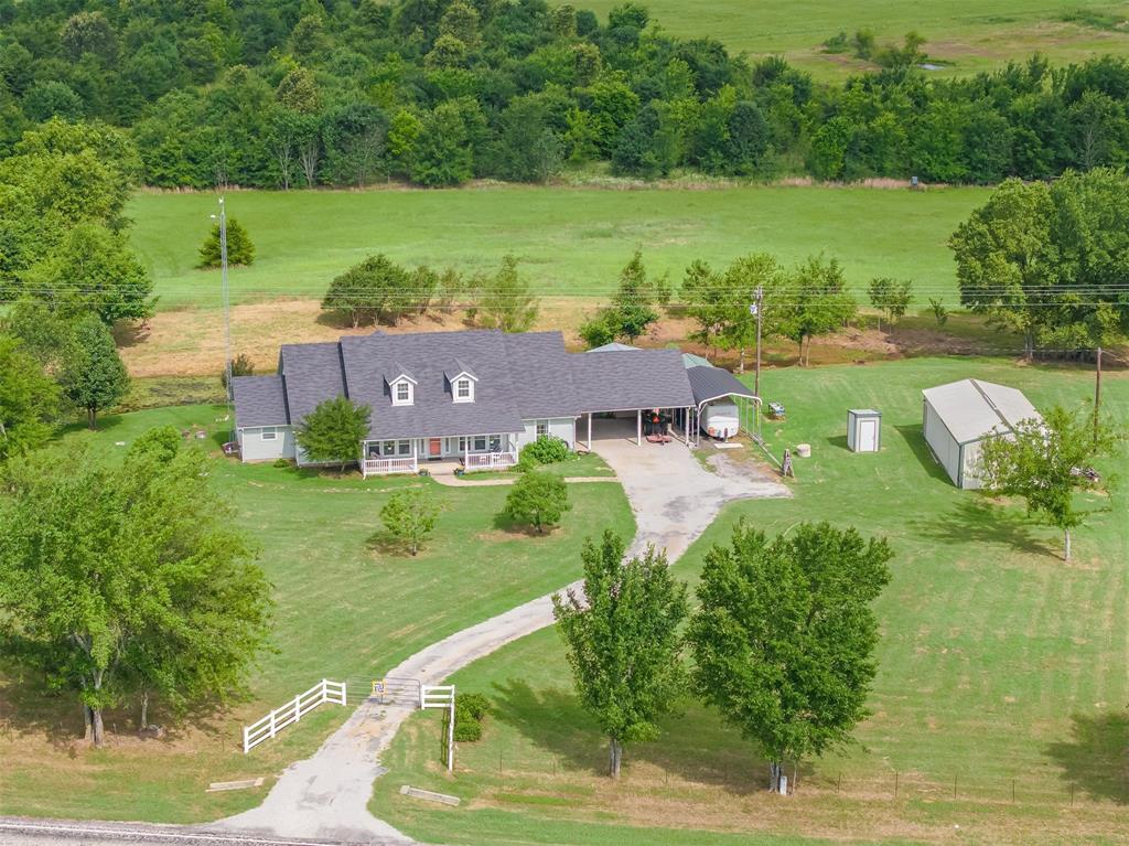 Set behind a gated entrance on 5.8 acres, this custom-built country home was originally designed as a bed & breakfast and offers a level of flexibility that's hard to find. Whether you're looking for a family home, guest retreat, Airbnb opportunity, or multi-generational setup, this property is ready to adapt to your vision. The home features 3 spacious bedrooms, each with its own private en-suite bathroom, creating comfort and privacy for family members and guests alike. Dual HVAC systems provide efficiency and allow for flexible use of the home's layout. Designed with hosting in mind, the floorplan makes it possible to operate part of the home as a short-term rental or bed and breakfast while maintaining private living quarters, or simply enjoy it as a traditional single-family residence. Need more space? The walk up attic could be finished out to expand the home with additional bedrooms, office space, or storage. You'll also appreciate the oversized laundry room with a dedicated sewing and craft space, providing plenty of room for hobbies, projects, homeschooling, or creative work. Outside, you'll find everything you need to enjoy country living. Relax on the back porch overlooking the pond, work on projects in the shop, tend to your plants in the garden room, or take advantage of the RV carport complete with hookups for guests or travel accommodations. The property also includes a barn, water well, and plenty of open space to enjoy. With room to grow, room to host, and room to make it your own, this is the kind of property that rarely comes available. Come see what life could look like with a little more space and a lot more possibilities.