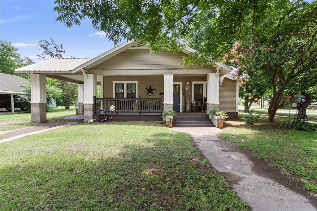 Welcome to this charming & well-maintained home that perfectly combines classic character with thoughtful modern updates. Located on a desirable corner lot just one block off Main Street, this property offers the convenience of being close to shopping, dining, schools, & community events while still providing the comfort & privacy of a residential neighborhood. Inside, you'll find 4 spacious bedrooms & 2 updated bathrooms. The fourth bedroom could also serve as a playroom, home office, workout space, or hobby area, providing endless possibilities. The home's open-concept layout creates a welcoming atmosphere, making it ideal for both everyday living & entertaining guests. The kitchen opens seamlessly to the main living area, allowing everyone to stay connected while cooking, dining, or relaxing. Original hardwood floors add warmth & timeless appeal throughout much of the home. Both bathrooms have been tastefully updated, offering stylish finishes & added comfort for today's lifestyle. Recent improvements provide peace of mind for years to come. A new air conditioning system was installed in 2024, helping ensure energy-efficient comfort during every season. Fresh exterior paint enhances the home's curb appeal & highlights its inviting presence on the corner lot. Outdoor living is equally enjoyable. The covered porch offers the perfect place to start your morning with a cup of coffee, unwind after a long day, or gather with friends & family. Mature shade trees provide beauty & create a peaceful outdoor setting. A separate storage building offers valuable space for tools, equipment, seasonal decorations, or additional storage needs. This move-in-ready property delivers the perfect combination of location, flexibility, & charm. With its spacious layout, updated features, original hardwood floors, open-concept design, & convenient location near the heart of town, this home is ready to welcome its next owners.