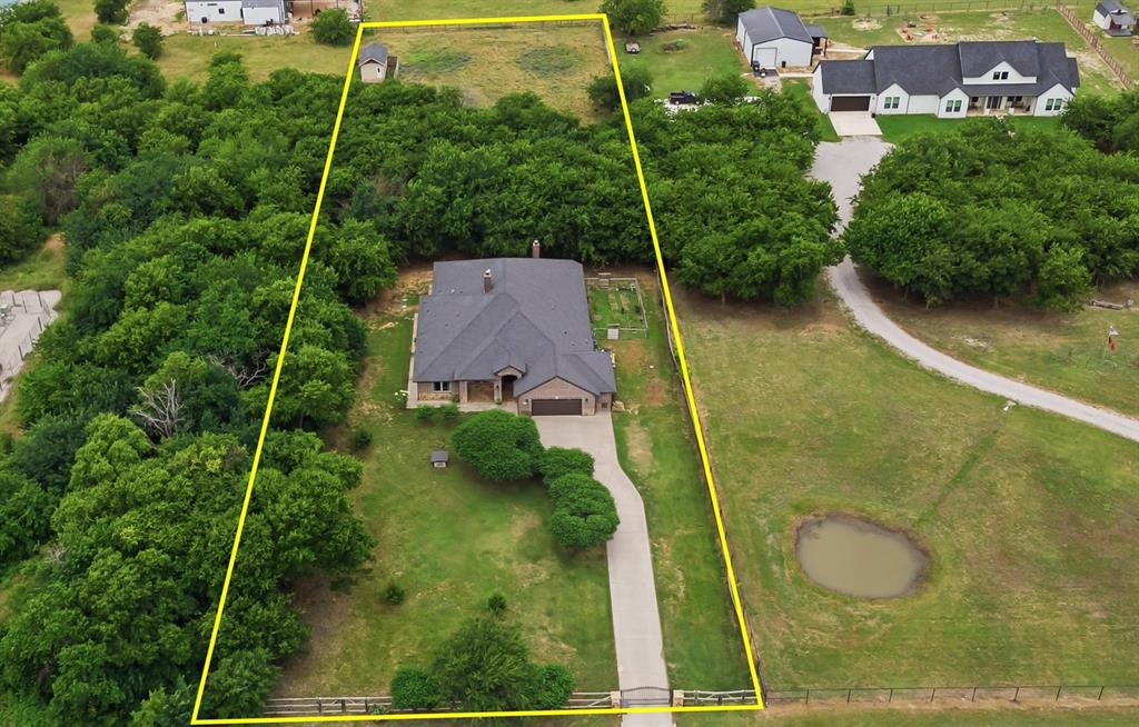 Gorgeous single-story, custom-built, single-owner home on 1.61 acres designed for country living with exceptional modern comforts. Spray-foam-encapsulated and open-concept, this 3,475-square-foot home offers four bedrooms and 3.5 baths. The primary suite features an oversized walk-in closet, a spacious bathroom with a large walk-in shower and ample storage. Two additional bedrooms each have walk-in closets and share a Jack-and-Jill bathroom, while a fourth bedroom near the entry is ideal for guests or a home office. The chef’s kitchen features an oversized eat-at island seating five, generous prep space, a large breakfast area, a coffee nook, a 5-burner gas range with pot-filler, a custom exterior-vented hood, a large walk-in pantry with electrical outlets behind shelving, and upgraded black stainless appliances—perfect for everyday meals and entertaining. Wood-look porcelain tile flows seamlessly throughout the home, combining elegance with easy maintenance. The living room opens to the kitchen, creating a spacious great-room feel with uninterrupted sightlines; high ceilings and abundant windows flood the space with light, and a cozy fireplace adds warmth and ambiance. An adjacent room can serve as a formal dining area, second living room, playroom, or man cave, and there’s a media room for additional entertaining options. The large covered patio features its own fireplace for comfortable evenings, plus a convenient exterior half-bath for outdoor living and entertaining. The concrete slab was engineered with piers and beams for extra strength, and the concrete driveway leads to the two-car garage. A 12' x 20' spray-foam insulated outbuilding has been converted for maximum storage. The property is fenced and cross-fenced, includes two poultry coops and a livestock run-in—meticulously cared for and move-in ready, just bring your animals! Just minutes away and close to shopping, dining, and all the boots in downtown Justin! Zoned for NEW Barksdale Middle Fall 2026.