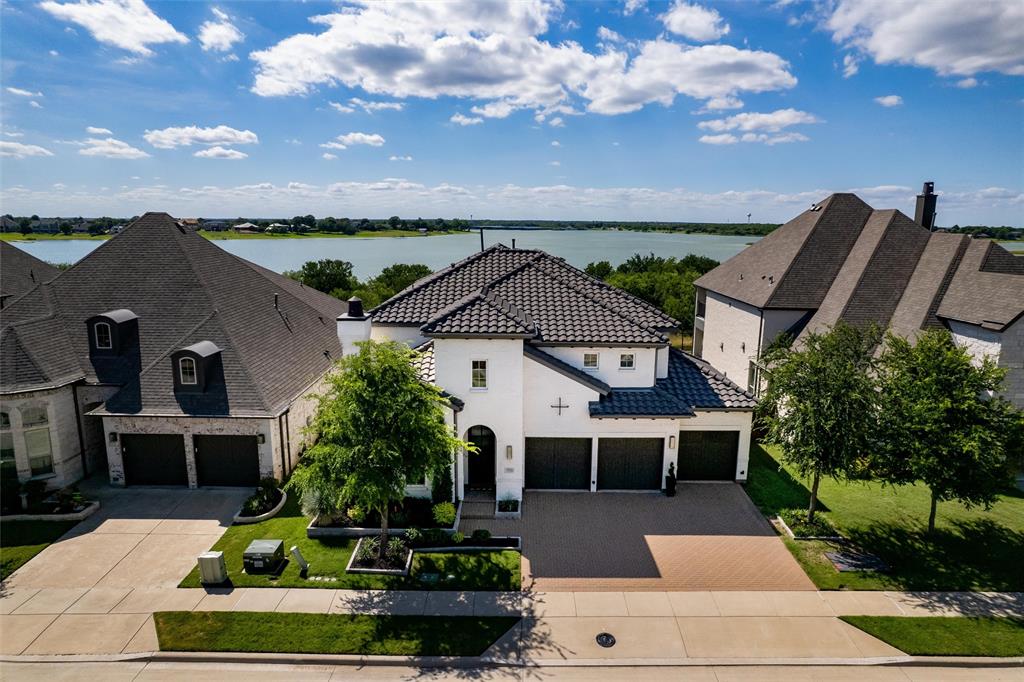 Big Price Reduction for this Rare Lakefront Opportunity in Premier Master-Planned Golf Community w Incredible Amenities. Amazing views of Lake especially in Winter & Spring w year around privacy & a gorgeous tree lined lot Welcome to your dream home on one of the most sought-after streets in this prestigious lakeside neighborhood. This custom designed modern masterpiece offers an unmatched blend of luxury, functionality & location, truly the perfect home on the perfect lot. From the moment you arrive, the stunning curb appeal sets the tone for what’s inside. This spacious 4-bedrm, 5-bathrm home features a thoughtfully designed floor plan w no detail overlooked. A dedicated study w built-ins & a stylish formal dining room offer elegant spaces for work & entertaining. At the heart of the home lies a chef-inspired kitchen complete w quartz countertops, upgraded backsplash, top-of-the-line appliances, & abundant storage. The open-concept layout flows seamlessly into the expansive living area w a cozy fireplace, ideal for everyday living & gatherings. The main floor includes both the primary suite & a secondary bedrm w ensuite bath, perfect for guests. Upstairs a custom beverage station, massive second living-flex space, media rm, & two additional bedrms. Designer touches throughout include custom paint, lighting, & curated finishes. Step outside to your private backyard oasis that backs directly to the lake, featuring a covered patio, pergola, & outdoor kitchen w leathered granite countertops. It’s the perfect setting for peaceful mornings or lively evening entertaining. Additional highlights, Primary Custom closet & Custom Pantry, spacious 3-car garage w built-in storage & access to top-rated schools. Living in the Tribute means more than just owning a home, it’s a lifestyle. Enjoy two golf courses, resort-style pools, an 800-slip marina, on-site dining, lakeside trails, & amenities like dog parks, pickleball courts, a splash pad, kayak-canoe launch & the list goes on
