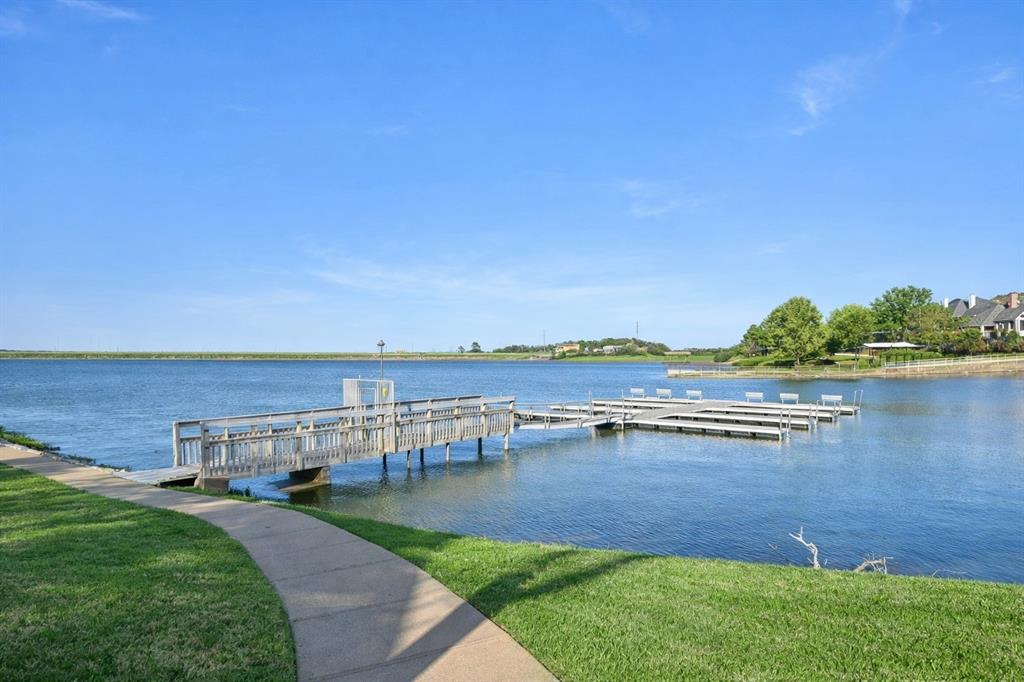 Timeless charm meets everyday functionality in this stately home located in Bay Club along the shores of Lake Arlington. Grand entry with soaring ceilings, wood floors, custom millwork, welcomes you into multiple living and dining areas ideal for entertaining. The spacious kitchen featuring premium Viking appliances and a large island opens seamlessly to the main living space. Light filled sunroom offers the perfect spot to relax, unwind, or enjoy morning coffee year-round, The private primary suite is located on the main level and features dual vanities, a walk-in shower, and garden tub. Flexible secondary bedrooms provide space for guests or a home office. Enjoy outdoor living on the elevated deck, ideal for entertaining or peaceful evenings outdoors. Bay Club is an active community offering tennis, pickleball, a private clubhouse, and a boat dock. Don't miss the opportunity 
to experience this exceptional home and the Bay Club lifestyle in one of Lake Arlington’s most desirable, gated lakeside communities.
