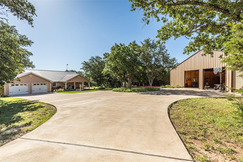 Seller financing available!!!!!  Substantial Price improvement! Looking for a peaceful spot in the country without giving up convenience? This 3 bed, 2 bath custom home sits on just over 7 beautiful, wooded acres and is perfectly located between Ft. Worth and Waco, just minutes from Lake Whitney—a great spot for fishing, boating, or just kicking back by the water.

Built by the owner, a master craftsman, the home features quality construction, a smart floorplan, and a warm, welcoming feel throughout. Outside, the property is full of natural charm, with lots of wildlife and a seasonal creek that runs through it—perfect for nature lovers.

And then there's the huge barndominium : a fully equipped 1 bed, 1 bath guest house on one side of the massive 3,600 sq ft building fully insulated, electricity, and water. It includes a large, separate workshop space that's a handyman’s dream, plus about 800 sq ft of upstairs storage. 
Whether you're into projects, outdoor adventures, or just want a little space to breathe, this place has it all. Come check it out and see what country living is all about!
House has a Fireplace Xtrodinair, an $8,000 upgrade with forced air.
House is built with 6 inch exterior walls and has spray foam insulation throughout.
Features solar panels that are attached to the roof of the shop and are paid for. Sellers can provide cost savings.