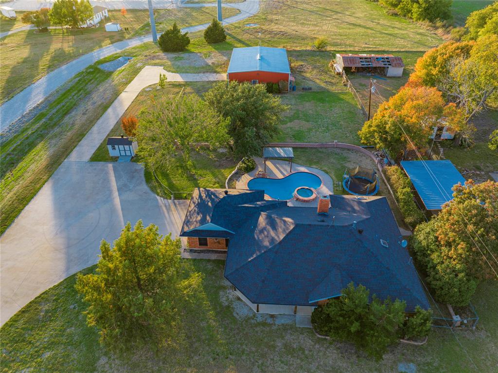DRASTIC PRICE DROP.... seller reflecting updates needed. You don't want to miss this Amazing Property!  3-2-2 acreage outside city limits, no city taxes! Has propane and septic. Huge 40x60 workshop with enclosed office. Shop has water and separate electricity along with lots of extras ready for the serious shop guy!  Watch the gorgeous Texas sunsets in your big fenced in backyard, while relaxing in the beautiful, newly resurfaced pool or hot tub, or enjoying your favorite drinks under the gazebo.  Inside, enjoy plenty of room for you and your guests. Garage is right off the kitchen, making it easy to put away your groceries in your solid oak cabinets. Kitchen has stainless steel appliances including a gas stovetop. Ample laundry room with utility sink right off kitchen. Formal dining area. Beautiful, gas fireplace ready for your holiday decorating. Primary bedroom enjoys a large en suite bathroom with 2 WIC. Come add your touches to make this home yours!