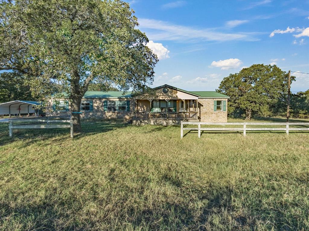 Morning light spills across forty acres of pasture and tree-dotted hills, the kind of view that reminds you why wide open spaces still matter. The open sky seems endless, with every sunrise casting new color over the grasslands and every sunset reminding you what peace really looks like. The 2,128-square-foot home sits at the heart of the property, perfectly positioned for panoramic views of your land. The front porch overlooks the landscape — a front-row seat to sunrises, storm clouds, and those sweeping Texas skies. Inside, you’ll find a home made for making memories, where everyone can gather. With four spacious bedrooms and three full bathrooms, there’s plenty of room for family, friends, and guests to feel right at home. A versatile flex space adds even more possibilities — ideal for a home office, hobby room, playroom, or even a fifth bedroom to suit your needs. The living room gathers everyone around a cozy fireplace, perfect for relaxing after a long day, while the den features a wood-burning fireplace that brings a touch of rustic charm and warmth.  Beyond the home, the acreage tells its own story. Pastures are already prepped for cattle or horses and features a stock pond. Mature trees offer shade and shelter, and the mix of open field and varied terrain gives the property both beauty and utility. Whether you’re tending livestock, tracing the heartbeat of the land on an ATV, or simply taking in the stillness of evening, this land has a rhythm all its own. It’s a place built to grow with you — a ranch where generations can work the land, raise livestock, and create a legacy that lasts a lifetime. Whether you’re building a future or continuing a tradition, this 40-acre spread offers the space, strength, and serenity to live your story.