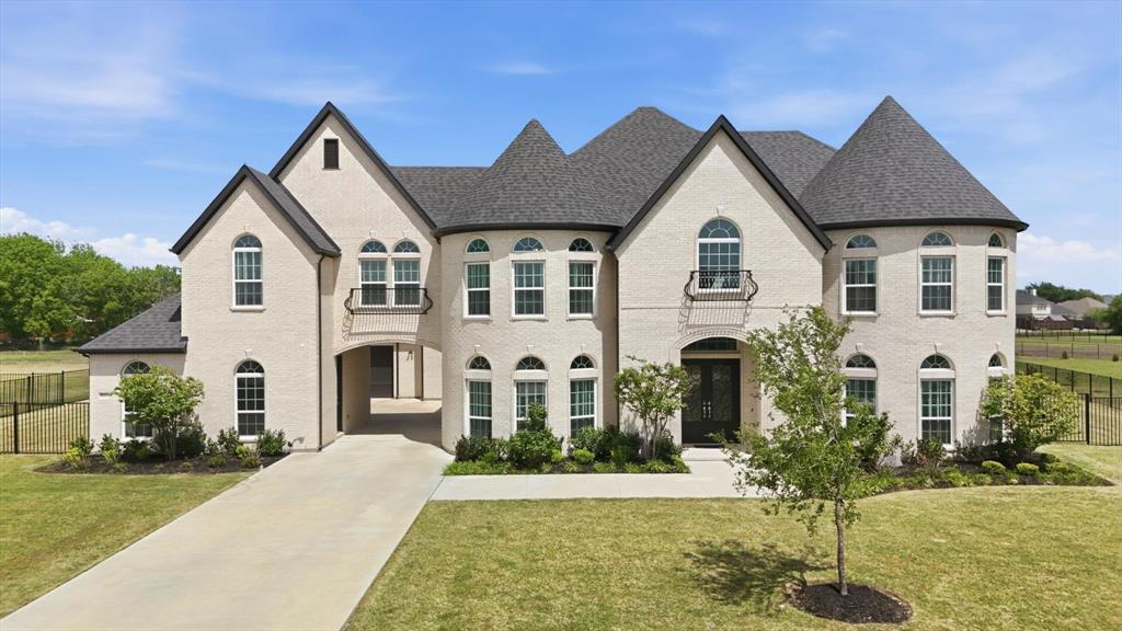 Completed in 2023, this CUSTOM-BUILT 5-bed,5.5-bath porte-cochere home with 4-car garage sits on an open 1.5 acre lot, standing out as a unique residence within the subdivision. Ideal for multigenerational living or elevated guest accommodations, this home offers 2 MASTER SUITES, 2 KITCHENS, and  2 laundry spaces, delivering an UNMATCHED level of rare convenience & luxury. The home's curb appeal is enhanced by its light-colored brick paired aesthetically with a striking, black roof.  Its architectural charm is elevated by 2 stunning turrets, adding a welcoming, timeless character to the exterior. The grand entry further welcomes you through impressive double iron doors into soaring ceilings. Warm, rich wood stairs catch your eye & add sophistication throughout. Inside, a breathtaking family room showcases coffered ceilings & a bold fireplace set against a floor-to-ceiling-tiled accent wall. Elegant double crown molding is found throughout the main areas. Perfect for everyday living or hosting, the home boasts a 2nd kitchen separate with full appliances, complemented by an entertainer's dry bar by the breakfast nook. Both kitchens feature soft-close cabinetry, & soft-closing drawers are found throughout the home, enhancing its designer appeal. All 5 bedrooms are thoughtfully crafted with ceiling fans & integrated lighting. Each offers a private ensuite bathroom with a walk-in shower, ensuring comfort & privacy. One laundry space is discreetly integrated into the upstairs master suite closet for effortless living. Entertainment reaches new heights with a massive media room home theater, pre-wired for a future projector & 7.1 surround sound. Additional highlights include a covered porch with an upper rear balcony & an exquisitely finished iron fence enclosing the backyard for added style whilst spending the evenings outdoors. Offering an unrivaled combination of prestige, flair, & modern living, this extraordinary home is ready for you to make it your own.
