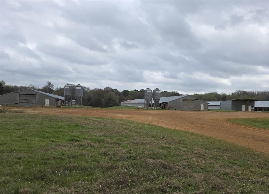 Former poultry farm on approximately 161 acres with endless potential. Property includes four former Pilgrims Pride chicken houses with grain bins. Pilgrims will no longer place birds at this farm, allowing the new owner flexibility to repurpose the houses for storage, equipment, or other uses. Improvements include a 1,512 sq ft 4-bedroom, 2 bath home with metal roof and metal siding that needs TLC but offers solid bones. Additional features include an office, walk-in freezer, and multiple storage areas on site. Beautiful acreage with excellent hunting, privacy, and several ideal locations to build your dream home. Conveniently located between Pittsburg and Gilmer with a Pittsburg address in Upshur County.