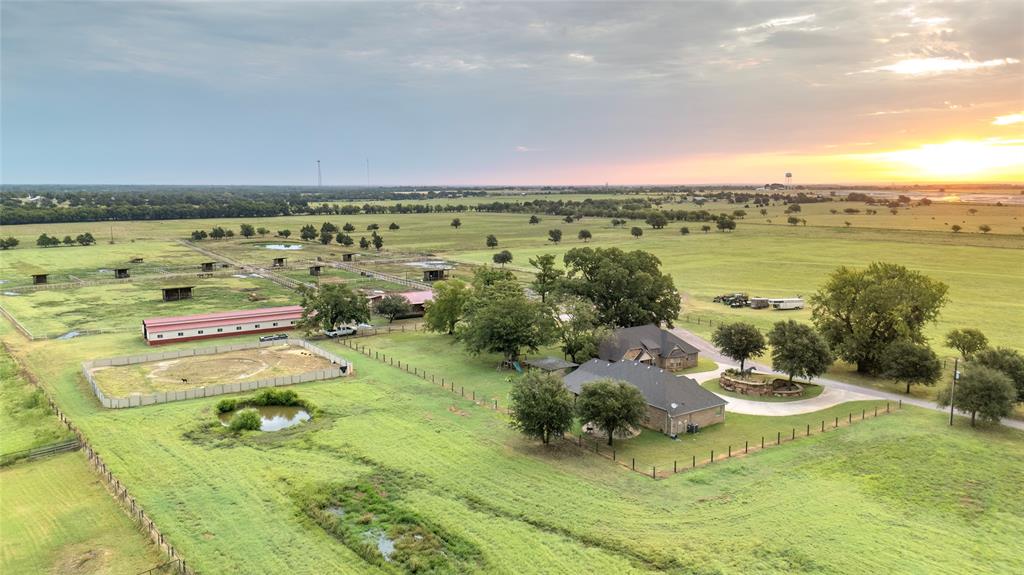 This 87-acre equine paradise offers TWO identical brick homes, each featuring three bedrooms, two and a half baths, and hardwood floors—perfect for multi-generational living, staff housing, or guest accommodations. A gated entrance with a long, tree-lined driveway sets the tone for this remarkable property, which also showcases an original Maritta McMillan equine statue as a focal point of arrival. The ranch is fully fenced and ag exempt, with 53 acres of hay pastures prime for development. Equestrian facilities include a show barn with 11x11 stalls and a brick alleyway, a massive 40’x100’ hay and storage barn, and a large shop with a three-carport. A separate barn is already prepped for completion as a mare motel, while over 20 spacious turnouts and a riding arena provide ample space for training and turnout. Combining functionality, space, and timeless beauty, this is a property you truly must see in person.