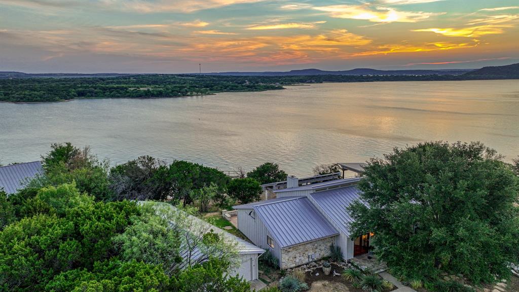 This updated home in Gaines Bend (with SHORT TERM RENTAL opportunity!) checks all the boxes: lakefront, dock, expansive views, ample indoor and outdoor living space, guest house and a great floor plan. Updates include new bathrooms with walk-in marble showers, quartz countertops, and double vanities, shiplapped walls and fresh white paint, ceramic tile flooring, nickel fixtures. Blink safety cameras, USB and power plugs in bedrooms, new wifi controlled garage door opener and more. The family room with vaulted ceilings is open to the kitchen and dining area. Doors in the spacious primary suite open to a covered patio. Secondary bedrooms with jack-n-jill bath.  Main house features 3 bedrooms, 2.5 baths while the bunkhouse provides an additional bedroom, bathroom and living space.  Enjoy sunset views of Hell's Gate from the oversized patio with fireplace. The two-level, private, deep-water boat dock with lift serves as an additional living area. SOLD FULLY FURNISHED.