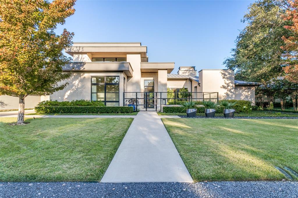 This contemporary home in Bluffview offers immaculate indoor and outdoor spaces with an open floor plan. Natural light cascades from the floor to ceiling windows and glass. Impressive cabinetry and a large island are the focal point to this gourmet center. Thermador stainless steel appliances and a nearby wet bar with wine refrigeration are great attributes. Primary bedroom is downstairs along with a secondary bedroom for guests. An office is close by as well as the utility room.  The spacious family room is conveniently located near the living areas. Up the stunning staircase is a central game room, as well as three guest bedrooms completing the second level. A covered patio with a seating area overlooking the spectacular pool and backyard complimented with mature landscaping and a firepit for lounging is another area to relax, making this a special outdoor retreat. This sleek interior blends with the multiple outdoor areas and has so much to offer.