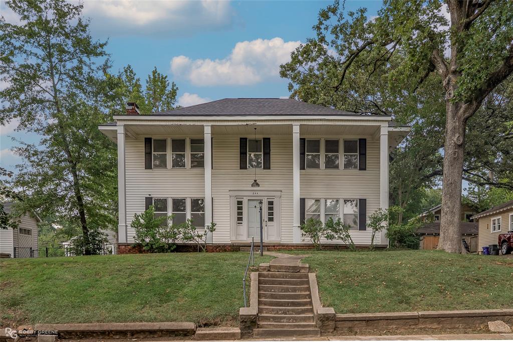 Nestled in the heart of the Gladstone Historic District, this stately colonial-style home offers a rare blend of timeless elegance and generous living space. Boasting 5 bedrooms and 2 full bathrooms, it showcases classic columns, original hardwood floors, and abundant built-ins that capture the charm of a bygone era. Expansive windows bathe each room in natural light, while a separate exterior entrance provides access to the upstairs living area and screened-in porch—perfect for relaxing or entertaining. The fully fenced yard features a side garden with an adorable shed, ideal for storage or a playhouse. Additional highlights include central heat throughout the home, air downstairs, and a detached garage for added convenience. Just minutes from Centenary College, LSU Ochsner’s Hospital, shopping, and dining, this historic treasure offers endless potential to create your dream home in one of the city’s most charming neighborhoods.