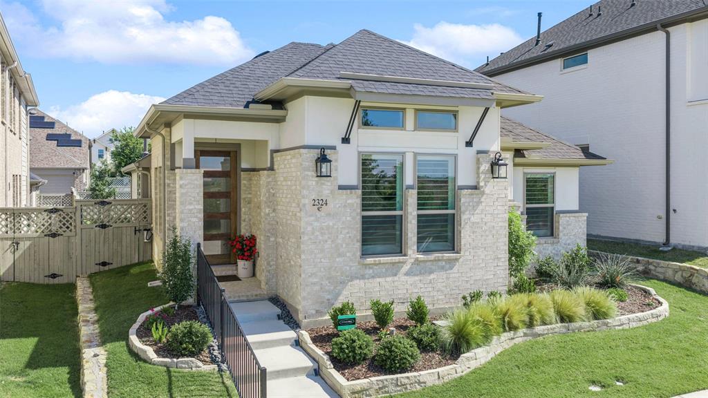 Beautiful Pecan Square home for sale in Northlake, Texas, featuring premium upgrades, green space views, designer finishes, and resort-style community amenities at 2324 Campfire Trail. Built by renowned Coventry Homes, this beautifully maintained single-story home is just 2 years old and truly feels like new. Situated on a premium lot overlooking green space, this 3-bedroom, 2-bathroom home offers added privacy, peaceful views, and an ideal open-concept layout designed for both everyday living and entertaining.
Inside, soaring ceilings, plantation shutters, designer finishes, abundant natural light, and warm luxury flooring create an inviting atmosphere throughout. The spacious living room features a beautiful fireplace and opens seamlessly to the kitchen and dining areas, creating the perfect flow for gathering with family and friends.
The chef’s kitchen is both functional and stunning with ceiling-height cabinetry, stainless steel appliances, a gas cooktop, subway tile backsplash, sleek hardware, and an oversized island with seating and storage. Privately tucked away, the spacious primary suite offers a spa-inspired bath complete with dual vanities, oversized walk-in shower, elegant finishes, and a freestanding soaking tub. Secondary bedrooms are generously sized and thoughtfully positioned for privacy.
Additional highlights include surround-sound prewiring, a whole-house water-softener system, an oversized extended garage with epoxy flooring, and a large covered patio.
Living in Pecan Square offers an unmatched lifestyle with HOA-covered internet and front lawn maintenance, three resort-style pools, pickleball and basketball courts, volleyball courts, parks, walking trails, weekly food trucks, and year-round community events. Families will also appreciate the brand-new middle school opening this fall. Combining thoughtful upgrades, like-new condition, exceptional community amenities, and a prime location, this home offers the very best of Northlake living.