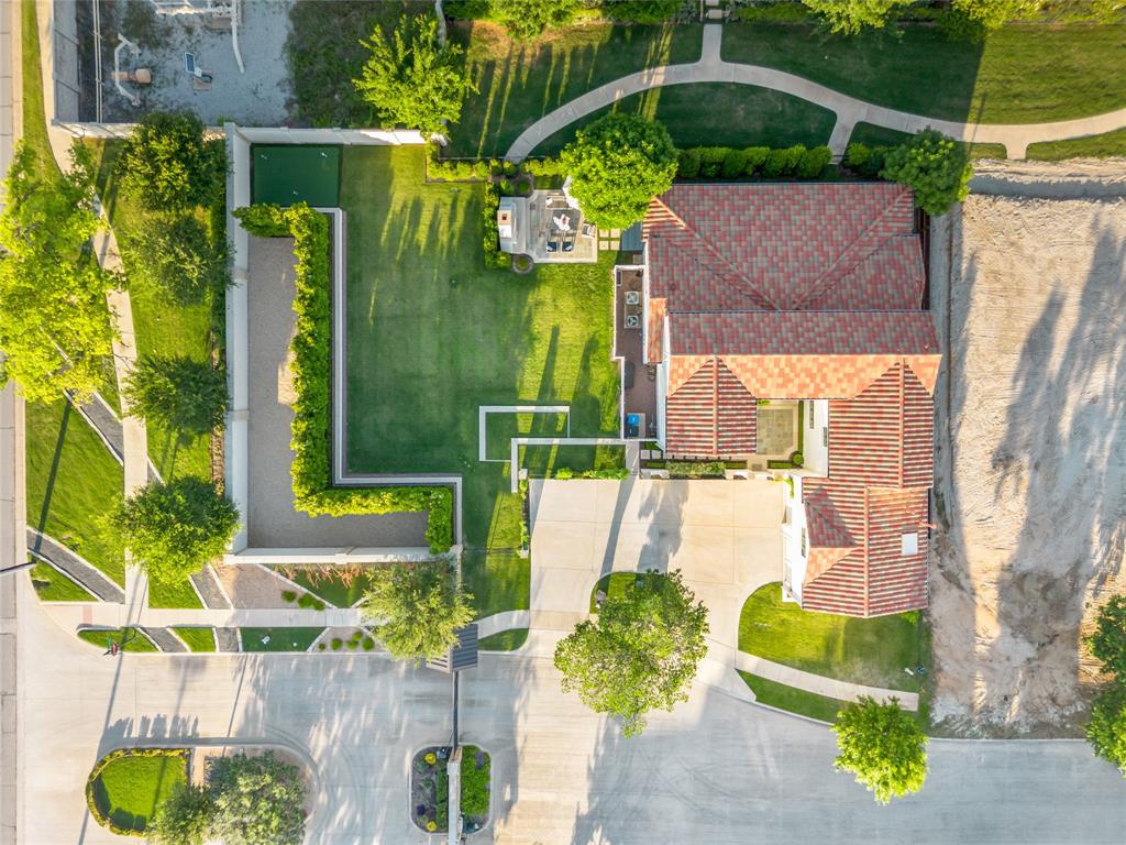 Rivercrest Bluffs is the hidden gem you’ve been searching for. Tucked into a scenic bend of the Trinity River, this premier gated community of less than 35 homes offers privacy, security & exclusive direct access to the Trinity Trails. Situated on a double lot, this stunning modern Spanish colonial revival home blends elegance, comfort & functionality throughout with designer finishes, spacious living areas & incredible indoor-outdoor flow. The first level features an open-concept layout with seamless flow from the kitchen to dining & living areas, creating the perfect space for entertaining or everyday living. The chef’s kitchen overlooks the main living & offers ample prep space, custom cabinetry & generous storage. The living room features custom built-ins that flank the gas fireplace. Also downstairs are the spacious primary suite, private office & full bath, providing flexibility for guests or work-from-home needs. Upstairs, a light-filled flex space provides endless possibilities for a second living area, game room, playroom or media room. The upper level also includes a secondary bedroom with en suite bath, a third bedroom with Jack-&-Jill bath connecting to the flex space, plus a fourth bedroom that could also serve as an additional flex space. Glass French doors open to an oversized covered patio spanning the length of the home, complete with built-in grill & bar area. Steps lead down to a beautiful outdoor fireplace patio surrounded by a massive, professionally landscaped yard with room for play, pets or a future pool. Mature magnolia trees create a natural privacy barrier along the 6-foot brick wall. A private wrought iron gate provides direct access to the greenbelt sidewalk leading to one of two gated Trinity Trails entrances. Located in the highly sought-after River District, residents enjoy local dining, boutique shopping, entertainment, parks & easy access to downtown Fort Worth. Minutes from Camp Bowie, Clearfork & the Cultural District.