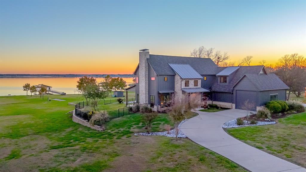 This custom-built home is situated on a rare 3.4-acre estate with a phenomenal 480 feet of pristine waterfrontage, protected by a steel retaining wall with a concrete sidewalk. The property is strategically designed to capture ample water views from nearly every room, with an industrial modern style.  It offers 3,800 sq. ft. of living space, 4 Bedrooms, and 5 baths.  The Primary Suite is conveniently located on the main level, while a second, equally spacious Primary Suite is located upstairs, plus a second living-game room, an additional guest room, and a huge bunk room for the kids with a full bathroom.  Open concept kitchen with gas stove, two ovens, two dishwashers, ample cabinet space, and two large pantry areas. The 3-car garage features ample storage, 18-foot ceilings, a pass-through carport, and a circular drive for ease of boat or RV parking.  This marine dream features a Boat Dock with two boat slips with custom boat lifts, cradles, and two jet ski lifts. The expansive covered patio creates a true outdoor living area for year-round entertaining and sunset viewing. The backyard is an adventure park unto itself, featuring a custom pirate ship playhouse and an exhilarating zipline that runs toward the lake. This property is the ultimate retreat for multi-generational living, entertaining, and outdoor recreation. Come tour the property on Richland Chambers Lake, Texas's third-largest inland reservoir and premier sailing basin.