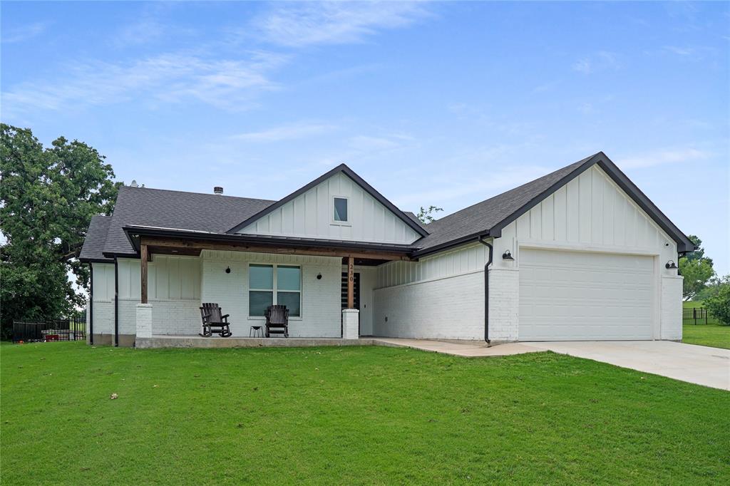 Discover refined country living in this stunning modern farmhouse, ideally situated within the scenic Runaway Bay resort community. Perfectly positioned along the 16th hole of the RB Golf Club, this home offers peaceful golf course views and is just a short stroll from the shores of beautiful Lake Bridgeport.
Step inside to an inviting, light-filled interior highlighted by soaring 10-foot vaulted ceilings and an open-concept design that seamlessly blends comfort and sophistication. Thoughtfully designed with a split-bedroom layout, this home provides both privacy and functionality. The spacious primary suite serves as a true retreat, featuring a spa-inspired bathroom complete with a freestanding soaking tub and an oversized glass walk-in shower.
Designer details shine throughout, including shiplap and board-and-batten accent walls, along with a chef-inspired kitchen offering abundant storage and stylish finishes—perfect for both everyday living and entertaining.
Enjoy the outdoors year-round with expansive covered front and back patios, ideal for relaxing and taking in the tranquil surroundings. The generous yard space adds to the home’s appeal, while additional features such as full encapsulated spray foam insulation, gutters, and dedicated space for a golf cart provide comfort, efficiency, and convenience.
This exceptional property combines modern elegance with laid-back lakeside living—an opportunity you won’t want to miss.
