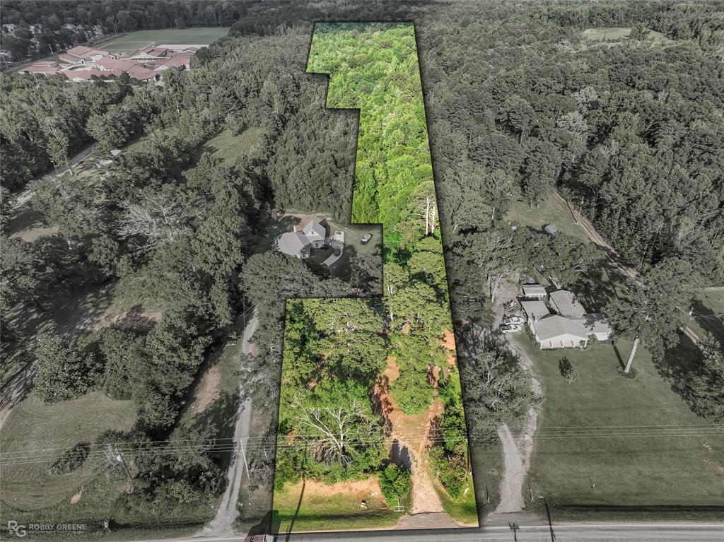 Discover an incredible opportunity to own 10 acres in the heart of Haughton, offering space, privacy, and endless potential. Whether you are looking to remodel the existing home, create your dream country retreat, or explore the possibility of rebuilding on a beautiful acreage setting, this property provides the kind of land and location that are hard to find. The wide front yard, mature shade trees, towering pines, hardwoods, and wooded surroundings create a peaceful setting with plenty of room for gardens, animals, equipment, recreation, outdoor living, or future improvements. The existing brick home offers 4 bedrooms, 2 bathrooms, and 1,976 square feet with a long single story layout and multiple living areas. The main living room features tile flooring, warm neutral tones, a ceiling fan, and a comfortable gathering space near the front entry. A second oversized living area or flexible bonus space showcases a dramatic stone fireplace wall, built in display ledge, large windows, and room for a den, game room, hobby area, additional living space, or possible reconfiguration. The kitchen includes abundant wood cabinetry, tile backsplash, granite style counters, pantry style storage, and a functional layout ready for everyday use. With its spacious floor plan, brick exterior, acreage, and versatile layout, the home offers a strong foundation for buyers who want to update, personalize, and make it their own. For those with a bigger vision, the 10 acre homesite presents a rare chance to design a new build or long term retreat surrounded by natural beauty while still being close to Haughton conveniences. This property is full of opportunity for someone ready to unlock its potential. A unique acreage property with space, privacy, and possibilities in Haughton. Call today to schedule your private showing!