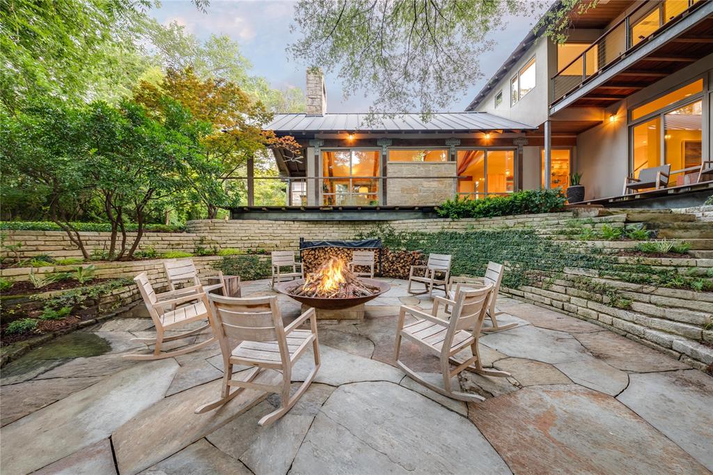Designed by Bill Larson of Larson & Pedigo Architects, this premier and private home is a rare find in Dallas. Located in the sought-after neighborhood of Devonshire, 5610 Farquhar offers the convenience of city living while transporting you into a rural oasis surrounded by mature trees and ponds. Modern yet rustic, floor to ceiling glass provides views of the sweeping grounds while blending seamlessly with warm yet contemporary interiors. You feel like you're in a modern cabin in the woods or a spread from Architectural Digest. Vaulted and beamed ceilings are found throughout and views are found in every room and every angle. Downstairs is complete with the primary suite, formal living and dining, library, den and chic kitchen. Upstairs has 2 bedroom suites, an office nook, balconies, and living space. Terraces and stairs descend to the pond below where a large patio awaits you with a firepit. designed to awaken your senses and bring you home to nature.