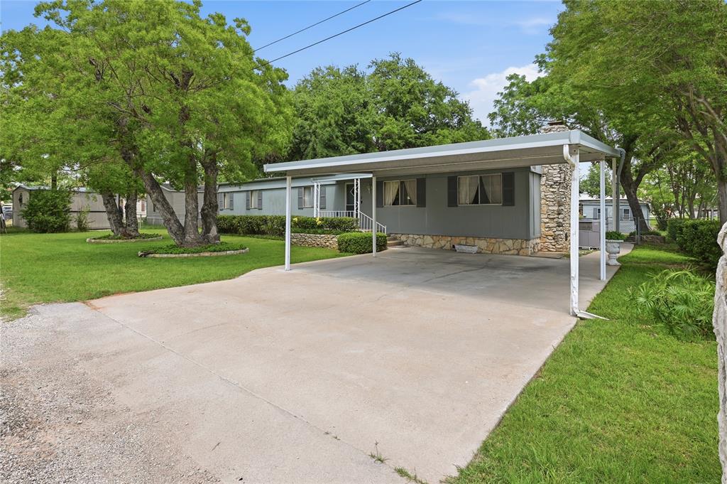 WATERFRONT - LAKE GRANBURY - DOUBLE LOT - BRING ALL OFFERS
A true renaissance is underway in the Ports-O-Call waterfront community — and this property positions you at the front of it.

If you have been waiting for an opportunity to secure waterfront property on Lake Granbury at a value entry point, this is it.

Ports-O-Call is one of the best located canal communities on the lake, offering wide, navigable canals with quick access to open water. What makes this opportunity unique is not just the water — it’s the momentum. Investment, improvements, and renewed interest are driving a noticeable revival throughout the neighborhood.

Situated on a rare double lot, the property features mature trees, highlighted by a stunning, oversized Live Oak that anchors the setting and will remain a defining focal point for years to come.

The home and accompanying outbuildings have been exceptionally maintained. The waterfront retaining wall, boat dock, and extended patio are all in very good condition — providing immediate enjoyment of the lake lifestyle.

The existing mobile home is in excellent condition and suitable for immediate occupancy. Alternatively, remove it and build new to capitalize on the lot size, waterfront setting, and community resurgence.

Whether your goal is weekend retreat, full-time lake living, or strategic investment, this property offers flexibility, location, and upside.

Come experience Ports-O-Call for yourself. 

The opportunity is real.

Welcome to Lake Granbury.