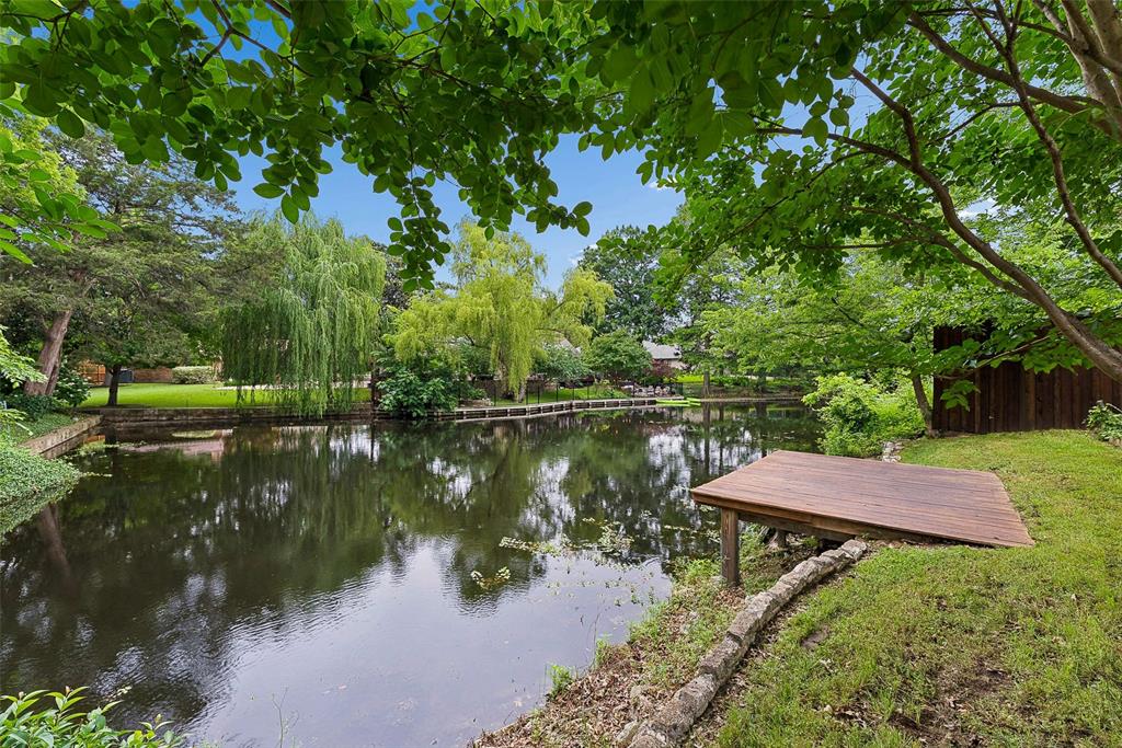 Beautifully reimagined and completely remodeled, this Lochwood home offers a seamless open-concept design paired with serene waterfront living. Hardwood floors flow throughout the main living areas, leading into a stunning island kitchen equipped with stainless steel appliances, quartz countertops, and a timeless marble backsplash. The inviting main living room is anchored by a cozy fireplace, creating the perfect gathering space, while a charming breakfast nook with a built-in storage bench adds both function and character. Just beyond, a fabulous family room showcases expansive views of the backyard and private pond, bringing the outdoors in.  The primary suite serves as a true retreat, featuring a double vanity, a generous walk-in closet, and an exquisite marble double-headed shower alongside a large soaking tub. Three additional generously sized bedrooms, plus a private office, offer flexibility for everyday living.  Set on an expansive one-third acre lot, the backyard is truly special, overlooking the tranquil water with its own dock—perfect for quiet mornings or evening unwinding. All of this on a peaceful, friendly street in one of East Dallas’s most sought-after neighborhoods.