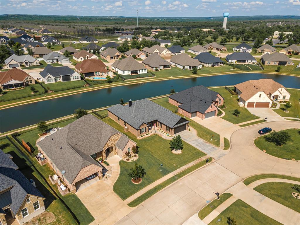 BREATHTAKING CUSTOM BUILT builder occupied 3 BD + office home situated on the canal in Pecan Plantation! Designed with an expansive open-concept floor plan, the family room, dining area, and kitchen flow seamlessly together, creating the perfect space for everyday living and entertaining featuring a stone gas fireplace. Walls of windows fill the home with natural light while showcasing peaceful canal views throughout the main living areas. Quality craftsmanship is evident with beautiful wood flooring, crown molding, a cozy propane fireplace, and a private office featuring tranquil water views. The spacious chef's kitchen offers a large center island, granite countertops, stainless steel appliances, abundant cabinetry, and a generous walk-in pantry.  The private primary suite is a true retreat with two walk-in closets and a luxurious ensuite bath featuring granite countertops, dual vanities, a soaking tub, and a separate walk-in shower. Outdoor living is just as impressive with a spacious screened patio (not included in the home's square footage), an additional open patio overlooking the canal, and epoxy-coated floors in both the patio and oversized garage. The approximately 768-square-foot garage includes space for multiple vehicles plus a dedicated golf cart garage. The oversized utility room offers extra space for an additional refrigerator or freezer. No carpet in the house! Enjoy the scenic canal setting complete with a walking path just outside your backyard. Aluminum fence to resist rust! Custon year-round decorative lighting. Recent updates include a new roof and fresh exterior paint in 2024. HVAC is American Standard 20 seer rated with varible sppeeds with 4 zones! Abundant insulation in this builder special! Canal maintenance dues are just $520 annually. This exceptional waterfront property combines luxury, comfort, and the sought-after lifestyle that Pecan Plantation is known for.