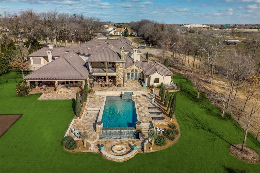 WELCOME TO YOUR STUNNING PRIVATE EXECUTIVE OASIS WITH PARK-LIKE SETTING IN HIGHLY DESIRABLE PROSPER SCHOOLS NEIGHBORHOOD. ON THE FIRST LEVEL IS A HOME OFFICE, EXERCISE ROOM WITH PRIVATE PATIO, TWO DINING AREAS, SPACIOUS FAMILY ROOM, SAFE ROOM,LAUNDRY ROOM WITH PET SHOWER,OPEN KITCHEN WITH CHEF’S STYLE WOLFE COOKING CENTER AND WINE ROOM. PRIMARY SUITE WITH TWO-SIDED FIREPLACE SEPARATED WITH SUN-DRENCHED SITTING ROOM.  GUEST QUARTERS WITH FULL BATH, AMENITY CENTER AND PRIVATE ENTRANCE.  ELEVATOR TO SECOND FLOOR FEATURES THREE BEDROOMS, LAUNDRY ROOM, MEDIA ROOM, GAME ROOM AND WALK OUT BALCONY WITH FIREPLACE. PRIMARY BATH HAS UNIQUE SANDSTONE TUB, SEPARATE SHOWER AND WIC. OUTDOORS IS A LUXURIOUS RESORT STYLE INFINITY POOL, FIRE PIT, WATERFALL, COMPLETE COOKING CENTER, POND, PLAYGROUND AND 3200SF PUTTING GREEN. TWO DOUBLE CAR GARAGES, SINGLE CAR GARAGE, LARGE WORKSHOP, PLUS EV CHARGING STATION. MINUTES FROM HWY 121, DALLAS NORTH TOLLWAY, SHOPPING, DINING AND AIRPORTS, ALL EASILY ACCESSIBLE.