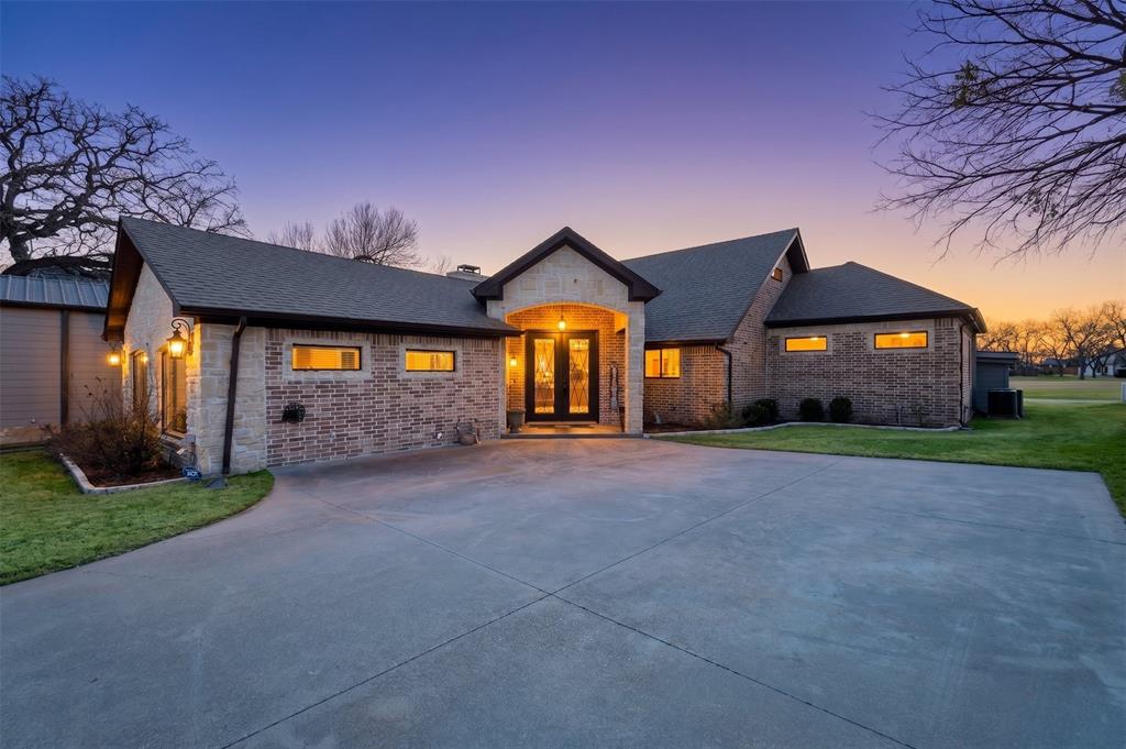 From the moment you arrive, stunning brick & stone architecture paired with dramatic dual iron entry doors set the tone for the luxury that awaits inside. Perfectly positioned along the 4th fairway, this beautifully renovated home offers the rare combination of refined interiors & resort-style living-all without lifting a finger, because the work has already been done for you. Inside is a light-filled, open-concept layout where the living, dining & kitchen spaces flow seamlessly, designed with entertaining in mind. Arched walkways, soaring windows, LED lighting & a clean neutral palette create a sophisticated yet welcoming atmosphere that suits any style. The kitchen features crisp white cabinetry, granite counters & two pantries for all your hosting essentials. A bright picture window above the sink ensures the chef never misses the view while guests float between the indoor living spaces & the outdoor oasis just beyond the large rear windows overlooking the pool & golf course. Oversized primary suite, offering generous space,  spa-worthy ensuite & walk-in closet that is honestly the stuff of dreams. Also on the main level, you'll find a versatile game room (or additional bedroom), full bath, pool bath & laundry room-making it effortless to host overnight guests & pool parties alike. Upstairs, 2 more generously sized bedrooms & a full bath provide the perfect private retreat. Outside, your personal paradise awaits. The fully fenced, landscaped yard showcases a sparkling pool with waterfall features & massive covered porch with beautiful stained wood ceilings perfect for al fresco dining. A two-car or RV tandem garage, golf cart garage & additional storage room complete this property. Life in DeCordova Bend Estates feels like a year-round vacation with golf courses, tennis & pickleball, volleyball, lake access & vibrant clubhouse. Just hop in your golf cart & go! Come see it!