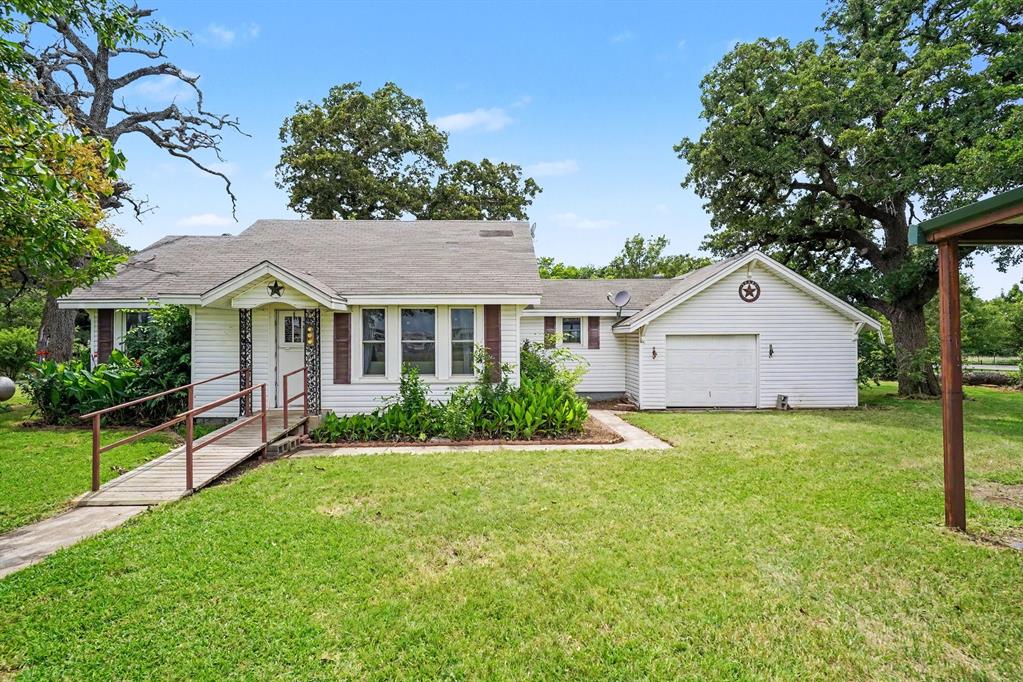 Charming 2-bedroom, 1-bath home on HWY 171 in Covington, TX, offering a peaceful rural setting on .818 acres. Located just half a mile from schools, 15 miles south of Cleburne and 10 miles west of I-35, this property provides quiet country living with convenient access to shopping and major highways. The home features white vinyl siding with burgundy shutters, a carport, and a garage with a workshop plus a large attached storage room. Mature trees and lush St. Augustine grass create a beautiful, shaded landscape. A storage shed is located in the backyard. Updates include windows replaced in 2014. Kitchen appliances include an electric range, refrigerator, plus washer and dryer. Home is serviced by propane.