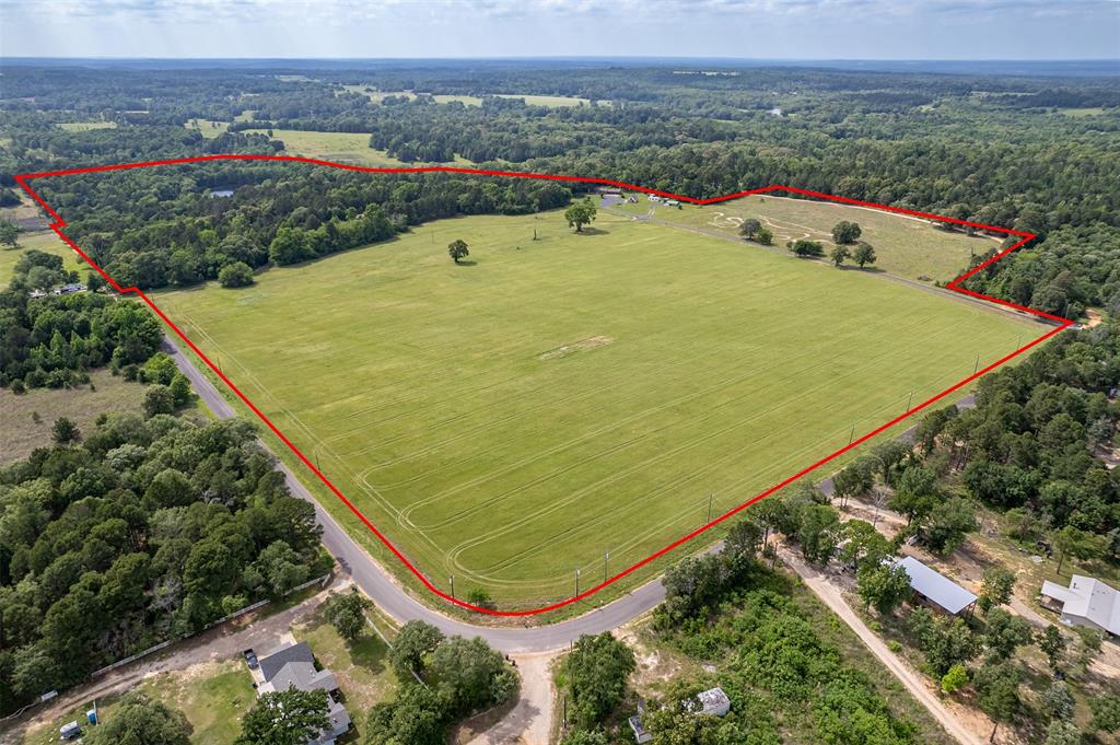 106.593 surveyed acres in East Texas with frontage all along County Road 3147 in northern Smith County, offering an excellent combination of pasture, timber, and water. The property features an estimated 60% wooded acreage and 40% improved pasture, making it well-suited for recreational use, livestock, or a future residential estate.

A standout feature is the spring-fed pond measuring approximately 5.5± acres, providing both scenic appeal and functional water for recreation and wildlife. Cleared lake frontage, established pasture lanes, and existing road access enhance the overall usability of the tract.

Two residential structures are present. The primary home offers potential for renovation or updating, while a secondary homesite near the lake includes structures that are likely best suited for removal and redevelopment, allowing a buyer to take full advantage of the lake setting. A shop outbuilding remains usable and provides practical utility for equipment storage or ranch operations.

The property is located within a rural residential and recreational corridor, surrounded by larger landholdings, farms, and homesteads, making it attractive to long-term landholders, recreational buyers, or estate-scale residential purchasers seeking acreage with a water amenity.

Overall, the property is priced primarily on land value, with existing improvements offering functional support rather than driving value—an excellent opportunity to acquire a sizable East Texas tract with water, privacy, and future potential.