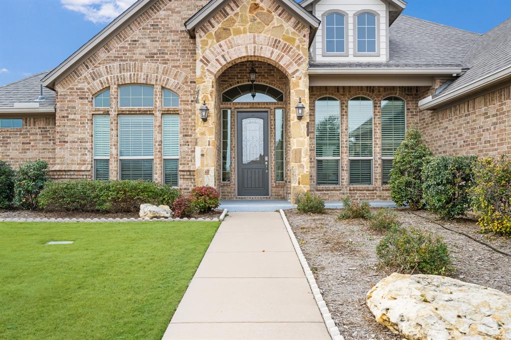 Set within a small, exclusive enclave in Joshua ISD, this beautifully updated brick and stone estate-style home sits on a 1.08-acre corner lot, offering privacy, space, and refined comfort. Properties of this caliber; combining acreage, location, and extensive recent upgrades are increasingly rare.
The thoughtfully designed 4-bedroom, 3-bath floorplan features 2 spacious living areas and 2 dining areas, ideal for both everyday living and entertaining. Recent investments include a brand-new roof, new coil in an HVAC system, fresh designer-neutral interior paint, and new carpet throughout, providing peace of mind and true move-in readiness. The kitchen and baths are finished with granite countertops throughout, while the expansive 3-car garage offers exceptional flexibility for vehicles, this stunning property also boasts a large additional structure, approximately 531 square feet, that could be storage, or a private workshop or 2-car garage. Step outside to enjoy a large, covered patio, professionally landscaped grounds, and trees — a serene outdoor setting with ample space to add a pool or create a custom outdoor retreat. Location is essential in the DFW Metroplex, and this property is situated just 13 miles from downtown Fort Worth, giving you a 15-minute commute to downtown, Fort Worth Stockyards, Sundance Square, and cultural hotspots such as Fort Worth Zoo with peaceful living. Offering acreage living, Joshua ISD schools, major system updates, and a multi-car garage in a refined, private setting, this home delivers long-term value and a lifestyle rarely available in today’s market.