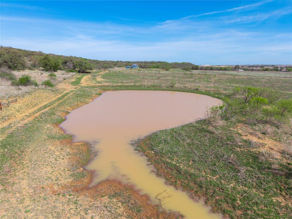 This versatile acreage offers endless possibilities for your Texas country lifestyle dreams, perfectly situated just a short, convenient drive from the heart of Brownwood, Texas a charming Central Texas community known for its small-town warmth, rich history, proximity to Lake Brownwood State Park, and easy access to outdoor recreation, local dining, and events. Nestled along paved road frontage for effortless year round access, this property is already set up for productive use and enjoyment: Excellent livestock ready infrastructure, including high quality, well maintained fencing throughout and a functional working pen area. A sturdy metal three sided shed provides reliable shelter for animals, equipment storage, hay, or tools keeping everything protected from Texas weather extremes. A dependable stock tank that holds water consistently, creating an ideal spot for wildlife attraction and excellent bird hunting opportunities doves, ducks, and more thrive here seasonally. Open, expansive terrain perfect for building your dream home imagine designing a custom ranch style house with plenty of elbow room, panoramic views, and privacy while still being minutes from town amenities. Whether you're envisioning a family homestead, a weekend retreat, or a full working ranch, the land's size and layout deliver flexibility: Roam freely on 4 wheelers, UTVs, or horses across the property. Raise cattle, horses, goats, or other livestock with room to rotate pastures and grow. Enjoy recreational pursuits like hunting, nature watching, or simply soaking in the peaceful Texas Hill Country vibes. Don't miss this rare chance to own a turnkey ready piece of Texas land with so much potential. Schedule your private showing today properties like this move quickly! Come see it soon and envision your future here.