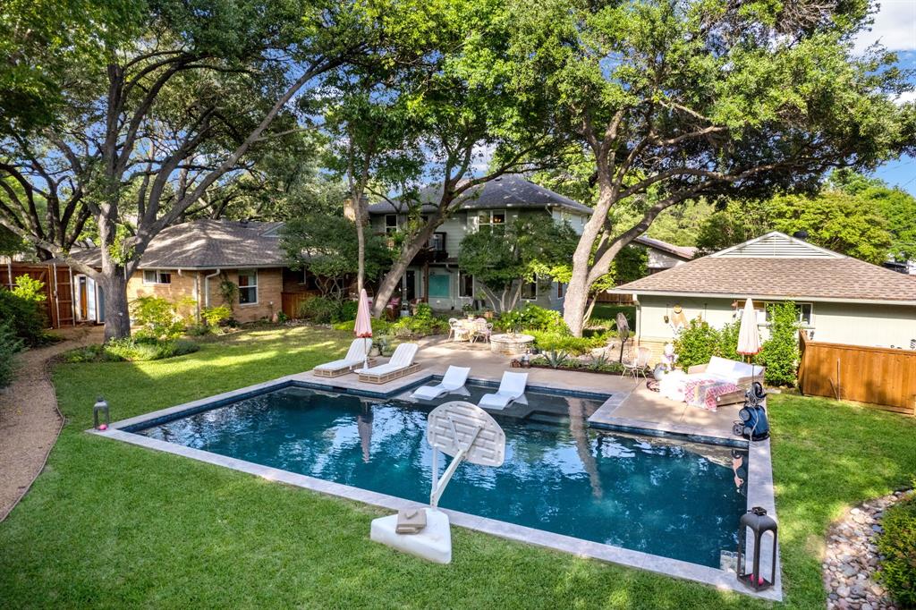 Tucked into one of Richardson's most coveted pockets on a rare cul-de-sac in Arapaho Heights— this 1961 beauty has been thoughtfully reimagined into something genuinely one of a kind. Covered porch, original built-ins, warm wood floors, brick fireplace, and a sense of calm that's scarce in the North Dallas suburbs. The kitchen flows the way life does: KitchenAid 5-burner gas range, honed stone countertops, peninsula with counter seating— open to the family and game room and connecting to the front living and dining spaces. French doors draw you to the backyard, and once you're there, it's hard to come back in. The 2020 linear saltwater pool— flanked by patios, lounging spaces, and lushly landscaped gardens beneath a canopy of mature trees — feels more private retreat than suburban backyard. Upstairs, the primary suite offers its own quiet world: spa bath with soaking tub, large shower, double vanity, walk-in closet, and a private balcony overlooking the backyard. A flexible bonus room off the suite offers nursery, studio, or office potential. Downstairs, the original primary suite includes a walk-in shower, dual vanity, seated vanity, and walk-in closet. Two additional bedrooms share a Jack & Jill bath with a dual vanity. Laundry is tucked away, near the back French doors. The detached oversized 2-car garage includes a climate-controlled workspace ideal for a studio or workshop. The converted original garage adds a spacious family and game room to the everyday footprint. Zoned for RISD: Arapaho Classical Magnet Elementary, West Jr. High, and Richardson High. Minutes from UTD, major medical and tech employers, and key commuter routes including 635, Central Expressway, PGBT, and the Dallas North Tollway. Homes like this with genuine character, rare lot, and exceptional location don't come available often in Arapaho Heights. 911 St. Lukes Drive doesn't just look the part— it feels like home from the moment you arrive, and makes you want to stay forever.
