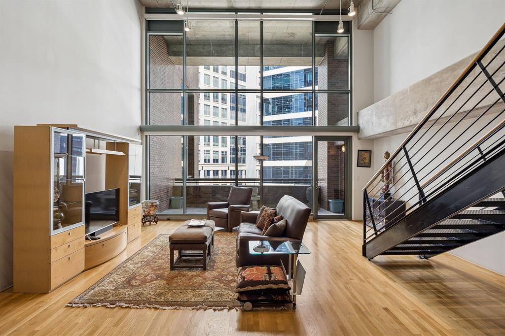 Experience authentic Uptown loft living at iconic 1999 McKinney Lofts. This highly walkable urban condo is a beautifully maintained residence that blends industrial-inspired architecture with expansive living spaces, soaring ceilings, exposed ductwork, and interior brick walls, giving the home true urban character. Approximately 20-foot floor-to-ceiling windows with motorized shades create a dramatic focal point in the main living area while filling the space with natural light throughout the day. The open kitchen-and-living design offers exceptional flexibility for entertaining and everyday living, with generous room sizes rarely found in newer construction. A large private balcony overlooks vibrant McKinney Avenue below, placing the energy of Uptown right outside your door.
The oversized first-floor bedroom functions beautifully as a secondary primary-style suite, while the expansive upstairs primary retreat includes a loft-style secondary living area overlooking the main level. Both bedrooms are exceptionally generous in size and offer strong separation and privacy. Storage space locker also comes with the unit and located near the fitness center.
Residents enjoy 24-hour concierge and security services, a fitness center, a conference room, a pool & spa, grilling stations, outdoor lounge areas, a fire-pit gathering space,  and 2 secured parking spaces. Just moments from the McKinney Avenue Trolley, Klyde Warren Park, the Dallas Arts District, Fearings, The Crescent, Whole Foods, American Airlines Center, Nick & Sam’s, Sixty Vines, Moxies, Del Frisco’s, and so much more.
Furniture can be sold. Refrigerator, Washer, and Dryer convey with purchase. 2 Parking spots Floor 2 spots 39 &  40
A rare opportunity to own in one of Uptown Dallas’ most recognized luxury loft buildings and enjoy a true lock-and-leave lifestyle in the heart of the Dallas in a premier Uptown location.