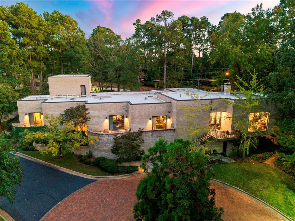 This architectural masterpiece was built with exceptional craftsmanship, solid construction, and a keen eye for detail. Every element of this home has been thoughtfully designed to create an unmatched living experience. Upon entering, you’re greeted by the grand living area with soaring ceilings and walls of windows that overlook the beautifully landscaped surroundings. On each side of the impressive fireplace, double French doors open to multiple outdoor living spaces. The formal dining room is truly a showstopper, featuring one of the most elegant and eye-catching light fixtures, making it the focal point of the space. Just off the dining room, you’ll find a stylish and functional wet bar equipped with an ice maker and mini dishwasher. A cozy secondary living area offers sliding glass doors leading to a private terrace patio. The chef’s kitchen is nothing short of spectacular. Featuring state-of-the-art appliances, double dishwashers, a wine refrigerator, gorgeous quartz countertops, and an inviting banquette dining nook that adds both charm and functionality. The primary suite is an absolute retreat, showcasing sliding doors to a private patio and one of the most unique en suite bathrooms you’ll find. Dual walk-in closets are spacious and thoughtfully designed to maximize organization and storage. Two additional bedrooms each feature en suite baths and access to patios. Upstairs, you’ll find a versatile flex space that is nearly finished and could easily serve as a fourth bedroom, office, or bonus room. Below the home, an unfinished basement of approximately 1,600 square feet provides endless possibilities. Choose to use it for storage or finish it out for additional living space. A pre-planned elevator shaft and designated area for a grand staircase are already in place for those wishing to take this home to the next level. Situated in the prestigious Palisades Subdivision, residents enjoy gated entry and lawn care included in the HOA dues.