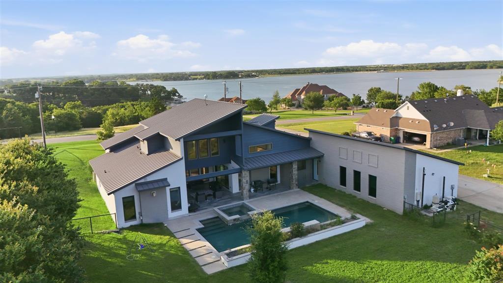 Welcome home to 211 Hunter Pass in Waxahachie, Texas, where modern luxury meets the warmth of country living and every detail is designed for the way you want to live. Set on 4+ private acres in Ellis County, this contemporary estate greets you with breathtaking front-facing views of Lake Waxahachie the moment you arrive, and delivers the space, comfort, and resort-style amenities you deserve with NO HOA.
Sunlight pours through expansive walls of windows, filling the open-concept floor plan with warmth and framing the serene lake views that welcome you home every single day. The chef's kitchen is the heart of the home, featuring marble waterfall countertops, a built-in Sub-Zero refrigerator, Miele oven and steam oven, commercial-grade gas range, beverage refrigerator, and a generous dining area where intimate dinners and large gatherings feel equally at home.
Three bedrooms and a dedicated study on the main level offer flexible living, while a private upstairs guest suite with full bath gives visitors their own space. Multiple fireplaces, a large mudroom, storm shelter, smart home features, spray foam insulation, a whole-home sound system, and abundant storage make daily life as easy as it is beautiful.
Out back, the resort-style pool and spa and expansive covered outdoor living area create a private retreat you will never want to leave and guests will never forget. The detached 33x40 barn and workshop includes custom horse stalls, a 220 RV plug, and a separate septic system, perfect for equestrian use, hobbies, or weekend projects.
Searching for a luxury home with acreage in Waxahachie, a horse property with pool and lake view in 75165, or a modern estate near Dallas built for living and entertaining? This is the one YOU deserve.