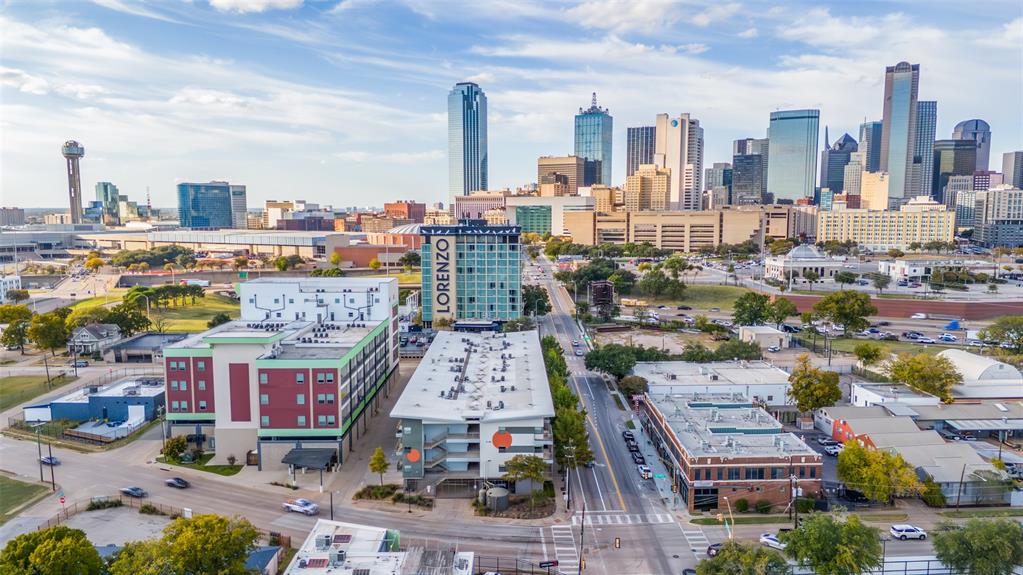 EXPERIENCE URBAN LIVING IN THE CEDARS NEIGHBORHOOD - BUZZ LOFTS IS FHA APPROVED. SELLER IS OFFERING a $5,000 Buyer Concession (with acceptable offer) that can be used for closing costs, rate buy-down or toward updates. RARE OPPORTUNITY to own a corner loft condo offering a 2-Bed, 2-Bath OPEN CONFIGURATION with an INCREDIBLE downtown Dallas view, 1152 sqft of urban living, 2 secure garage parking spaces (tandem). Located in a gated community in The Cedars, at the center of a vibrant district known for its energetic nightlife, eclectic art galleries & immediate proximity to Downtown Dallas. Designed with an urban open-loft aesthetic, this home features modern-type finishes, high ceilings, and a flexible open layout that adapts easily to your living arrangement. A roll-up garage-style door extends the living space onto the wrap-around corner balcony, where views of the Downtown skyline provide the perfect setting for entertaining or relaxing. Bamboo hardwood flooring is located throughout to create a seamless transition for the open floorplan.  The island kitchen is at the center of this space and offers frameless modern white cabinetry, deep storage drawers, butcher block countertops, stainless steel appliances, and a dual-basin stainless sink with high-arc pull-down faucet. The primary bedroom-bath area features an open wood-and-metal dual-sink vanity with a wood countertop, a tub-shower combo with glass sliding doors, white ceramic tile finishes, and a large walk-in closet. The guest bedroom area offers its own walk-in closet with barn-door entry, along with a white vanity, oversized porcelain sink & white ceramic tile finishes. Conveys with the unit: kitchen refrigerator and washer & dryer. This Buzz Lofts offers an urban lifestyle with an elevator, rainwater harvesting system, secure bike and storage area, and unmatched walkability to restaurants, shops, major highways, the DART Line, and all the culture of the Cedars District - just moments from Downtown Dallas.