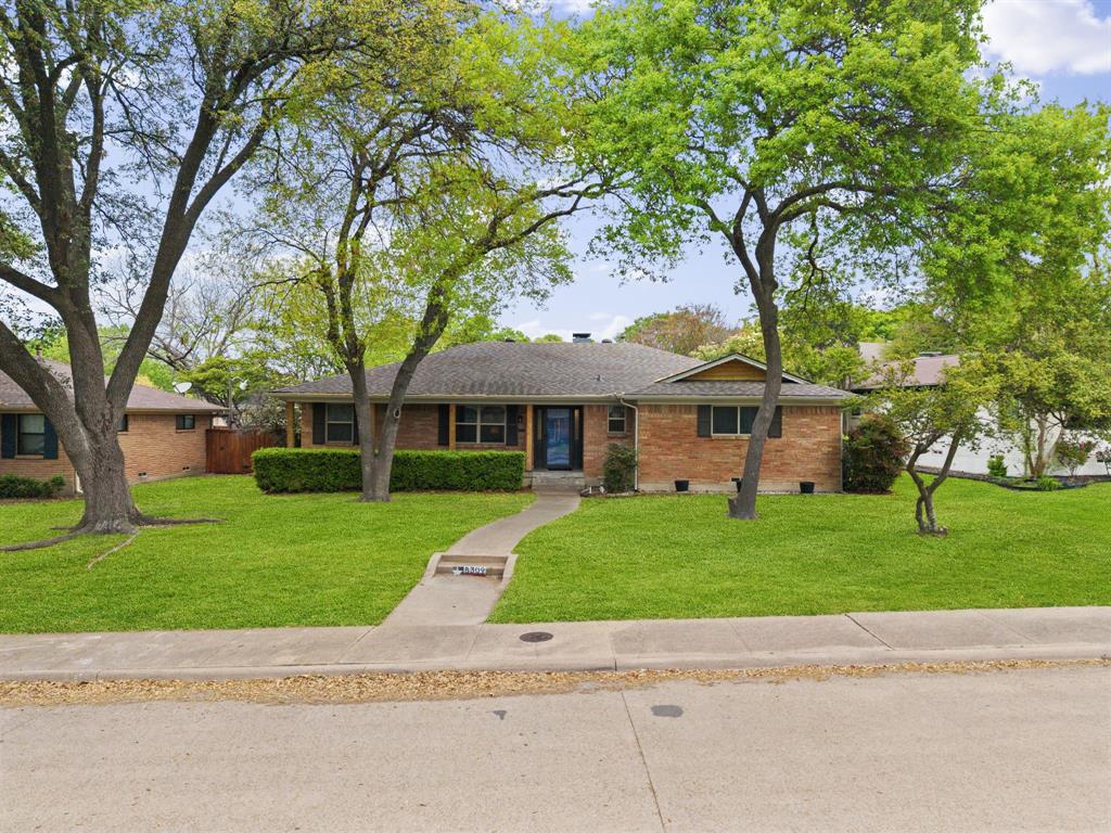 Welcome to 8309 Londonderry, a refreshed single-story brick home nestled on a tree-canopied street just 10 minutes from downtown Dallas. A covered entry leads to a versatile front living room with wide-plank LVP flooring, ideal for a home office, playroom, or formal dining. The updated galley kitchen is bright and efficient with quartz counters, crisp subway tile, under-cabinet lighting, stainless appliances including a gas cooktop and wall oven, and easy flow to a charming breakfast nook with wainscoting. Beyond, the spacious family room showcases vaulted beamed ceilings, a floor-to-ceiling brick fireplace, and custom built-ins. Oversized sliding glass doors draw in natural light and open to an expansive curved concrete patio, perfect for grilling, a fire pit, and outdoor dining, overlooking a private grassy backyard with two storage sheds and a rear-entry two-car garage secured by an electric gate. Two comfortable secondary bedrooms share a vintage-chic full bath with a shower and tub combo and rare dual access from both the hallway and a bedroom. The generous primary suite features a sliding barn door to a beautifully modern en-suite outfitted with dual vanities, a frameless walk-in shower with rainfall and handheld fixtures, a backlit mirror, and excellent linen storage. A combined laundry and pantry offers outstanding everyday organization with abundant shelving. Major improvements include new plumbing, new energy-efficient windows, and a new tankless water heater, all delivering comfort, efficiency, and style in one must-see 3-bed, 2-bath package.