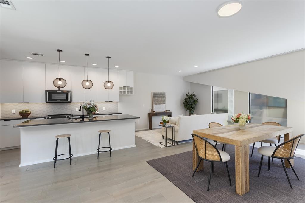 Modern, design-forward townhome in the heart of East Dallas offering a rare blend of smart technology, flexible living, and private outdoor space just minutes from Downtown, Uptown, and Deep Ellum. This three-story residence features an open-concept layout filled with natural light, clean architectural lines, and a seamless flow ideal for everyday living and entertaining. The chef-inspired kitchen showcases sleek quartz countertops, stainless steel appliances, and generous prep space, all opening to a spacious living and dining area designed for connection and comfort. Dual primary suites provide exceptional flexibility for roommates, guests, or multi-generational living, each with well-appointed baths and ample closet space. Additional flex areas create ideal options for a home office, fitness space, or media room. Office area can be used as third bedroom.  Smart home enhancements elevate the experience with integrated systems including app-controlled garage access, smart appliances, automated window coverings, and energy-efficient upgrades designed for convenience and modern living. Thoughtful details such as upgraded lighting, water filtration, and enhanced privacy features add to the home’s overall appeal. One of the standout features is the private yard, a rare find in this urban setting, paired with an attached two-car garage for added functionality. Located near some of Dallas’ most vibrant dining, entertainment, and cultural destinations, this home offers a dynamic lifestyle with walkable access to local hotspots while still providing a sense of retreat. A unique opportunity to own a modern, low-maintenance home in one of Dallas’ most desirable and evolving areas, combining location, technology, and lifestyle in one exceptional property.