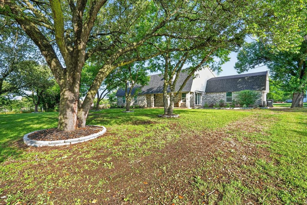 Completely renovated home on 1 acre in Burleson featuring extensive updates throughout, including spray foam insulation, new windows, new doors, flooring, fixtures, and finishes. Open-concept living area with modern fireplace design, updated kitchen, and spacious entertaining areas. Backyard includes an in-ground pool, covered patio, and large yard with mature trees. Convenient location with room to enjoy both indoor and outdoor living. Move-in ready.