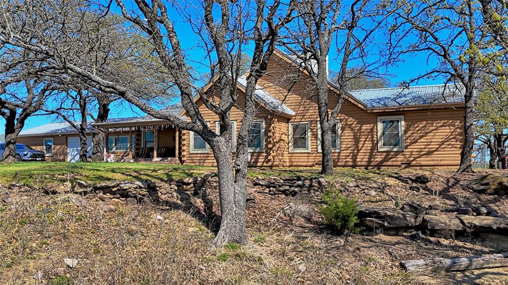 Imagine coming home to this custom-built log home nestled on 26.8 beautiful acres located outside of Nocona, Texas. This stunning property offers the perfect blend of comfort, functionality, and country charm.

The home features 4 bedrooms and 2 bathrooms, with a warm and inviting living room highlighted by a striking rock fireplace and a 16-foot chimney that extends to the top of the vaulted ceiling. The primary suite includes an ensuite bath with a custom walk-in closet, cedar-lined storage, and a separate tub and shower. The kitchen offers abundant cabinet space, and the home is equipped with a central vacuum system for added convenience.

Current owners have made several updates, including Anderson windows, an HVAC system, and an upgraded water heater. The large laundry room provides space for an additional refrigerator and freezer. Enjoy the versatility of the screened-in porch with updated windows—perfect for relaxing, entertaining, or creating a bonus living space. Additional features include a 3-car garage and a well house.

The property is well-suited for livestock and ranching, featuring multiple barns, workshops, and storage areas. The red horse barn, built less than 5 years ago, includes 5 stalls, a feed room, and a tack room. A 30' x 40' shop building features a roll-up door along with water, electricity, and plumbing already in place—ideal for a future cabin or additional living quarters. There are also additional barns and sheds for hay, equipment, animals, or extra storage. Animal pens with water access and a storage container add to the property’s functionality.

The land showcases a beautiful pond, Bermuda grass bottom land, scattered trees, and breathtaking views in every direction. The owners report the water well produces excellent water with strong pressure.

Whether you're looking for a full-time residence, a working ranch, or a private retreat, this exceptional property truly has it all—you don’t want to miss this one!
