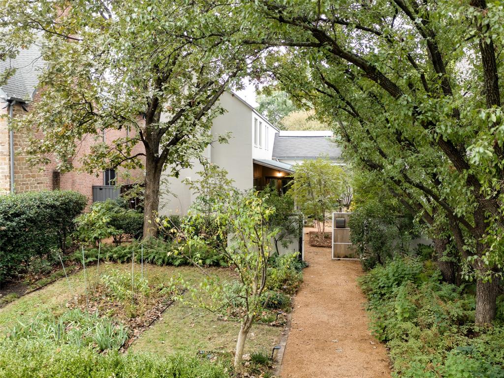 Designed by architect Frank Welch and nestled behind a gated courtyard, this inviting, modern home offers warmth, sophistication and privacy on a desirable Highland Park block. With its standing seam metal roof, trio of covered porches, and attractive blend of sleek and rustic materials, the house combines many elements of Welch’s Texas Modern vocabulary to create a stylish, unpretentious home with a casual, comfortable layout. 
A unique interplay of interior and exterior spaces, the first floor has abundant light and pleasant garden views from every room. The informal, open plan includes a cozy library with a fireplace and floor-to-ceiling bookshelves; a beautifully-scaled dining room; plus a gourmet kitchen & breakfast area and skylit family room with a trussed ceiling and additional fireplace. Upstairs, the spacious primary suite and three additional bedrooms are arranged for privacy along a windowed hallway. Built in 1995, the house has been well maintained, retaining the spirit of Welch’s original design, but is ready for your 2025 updates. This home also has a two-car attached garage with ample storage and its 50- ft. x 200-ft. lot features mature landscaping. Armstrong Elementary School, the Highland Park Pool, the Katy Trail and several parks, as well as the shops and restaurants on Knox Street, are all within walking distance. It is also a quick drive to the Highland Park Village, Snider Plaza, SMU and Mockingbird Station.