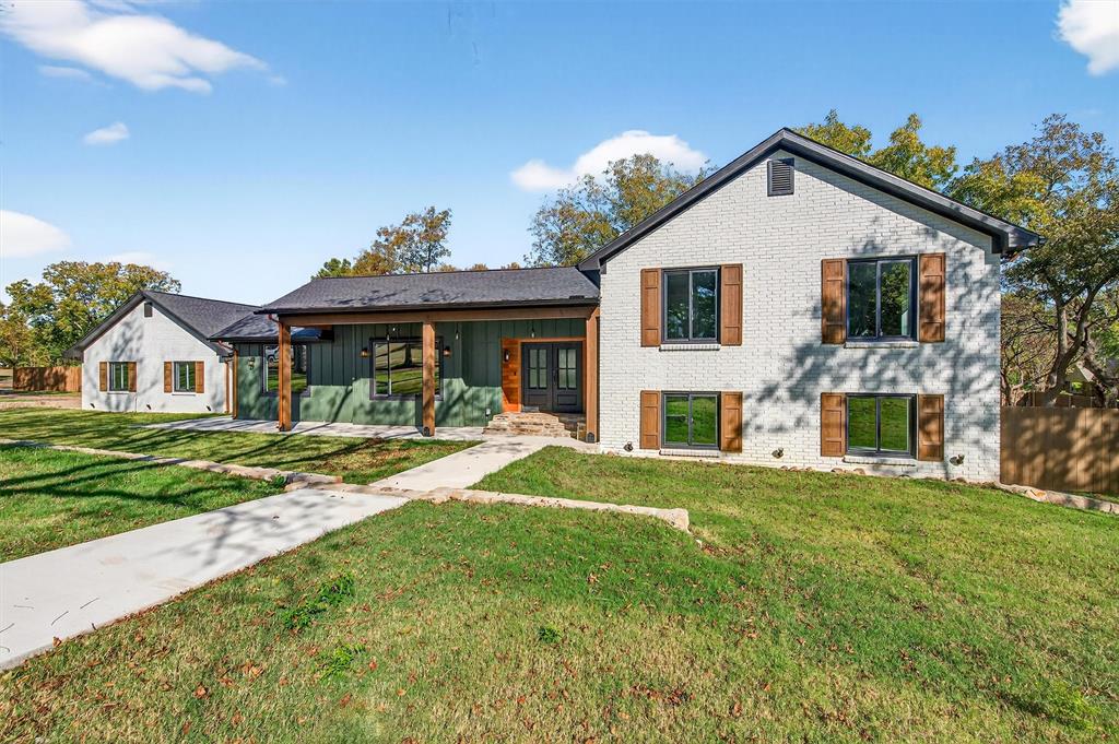 Beautifully reimagined 5-bedroom, 4.5-bath home on two wooded acres just outside the city limits. This home was essentially rebuilt from the ground up, giving you the peace of mind of new construction with the charm of an established property. With over 4,000 sq ft, the split-level layout offers multiple living areas and a walk-out basement perfect for a media room, game room, or private retreat. The kitchen and sitting area feature a vaulted ceiling with an exposed beam, solid wood flooring, and a striking chevron pattern in the kitchen. The gourmet kitchen includes a gas range, vent hood, refrigerator, and all new appliances. A light-filled laundry room with half bath and a large pantry add convenience. The primary suite includes a cozy wood-burning fireplace, private patio access, and a spa-style bath with soaking tub, walk-in shower, and custom closet with vanity. A second primary suite offers flexibility for guests or multi-generational living. Additional bedrooms are spacious and well-placed throughout the home. Outside, the large courtyard is ready for an outdoor kitchen or entertaining space. Located between Sherman and Denison and just minutes from Lake Texoma. HOA includes water and sewer. Truly move-in ready.