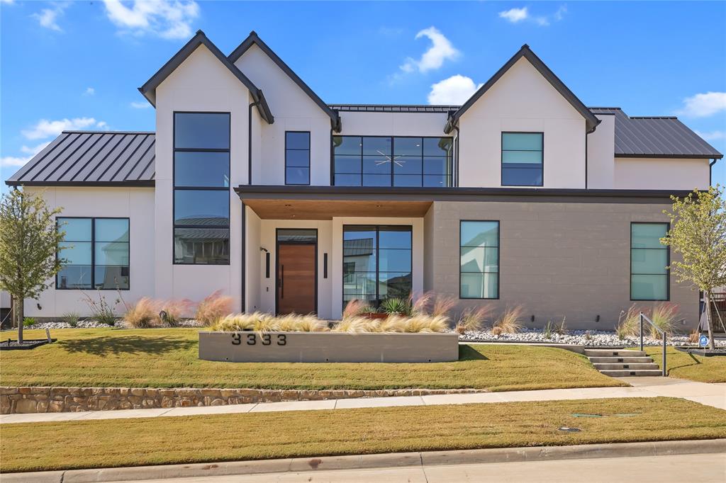 Located in the exclusive, gated community of The Hills of Kingswood, this Wald Custom Homes residence offers 6,401 square feet of well-planned living space designed for both everyday comfort and entertaining. The home features five bedrooms, five full baths, and two half baths, all finished in a warm, modern style.

The entry opens through custom iron and glass doors into a two-story foyer with a glass-enclosed wine display, formal dining area, and butler’s pantry. Wide-plank hardwood flooring and expansive windows carry throughout the main living areas. The kitchen is equipped with professional-grade appliances, custom cabinetry, and a large center island, and opens directly to the family room. Sliding glass doors lead to a covered outdoor living area with fireplace and built-in grill, creating a seamless indoor-outdoor flow.

The primary suite is located on the main level and offers a private retreat with a spacious bath that includes a soaking tub, oversized walk-in shower, dual vanities, heated floors, and a custom closet with center island. Two additional bedrooms on the first floor provide flexibility for guests or multigenerational living.

Upstairs includes two ensuite bedrooms, a game room with bar, a media room. There is also a climate-controlled flex space suitable for a home gym with a sauna, steam shower in 3rd bathroom, studio, or hobby room. An elevated study overlooks the main living area. Additional features include dual utility rooms, a three-car garage, a tankless water heater, and generous storage throughout.

Conveniently situated near The Star, Legacy West, Stonebriar Country Club, and the Dallas North Tollway, this home offers a desirable location with easy access to shopping, dining, and major employment centers. Thoughtfully built and competitively priced, this property presents a strong opportunity within The Hills of Kingswood.