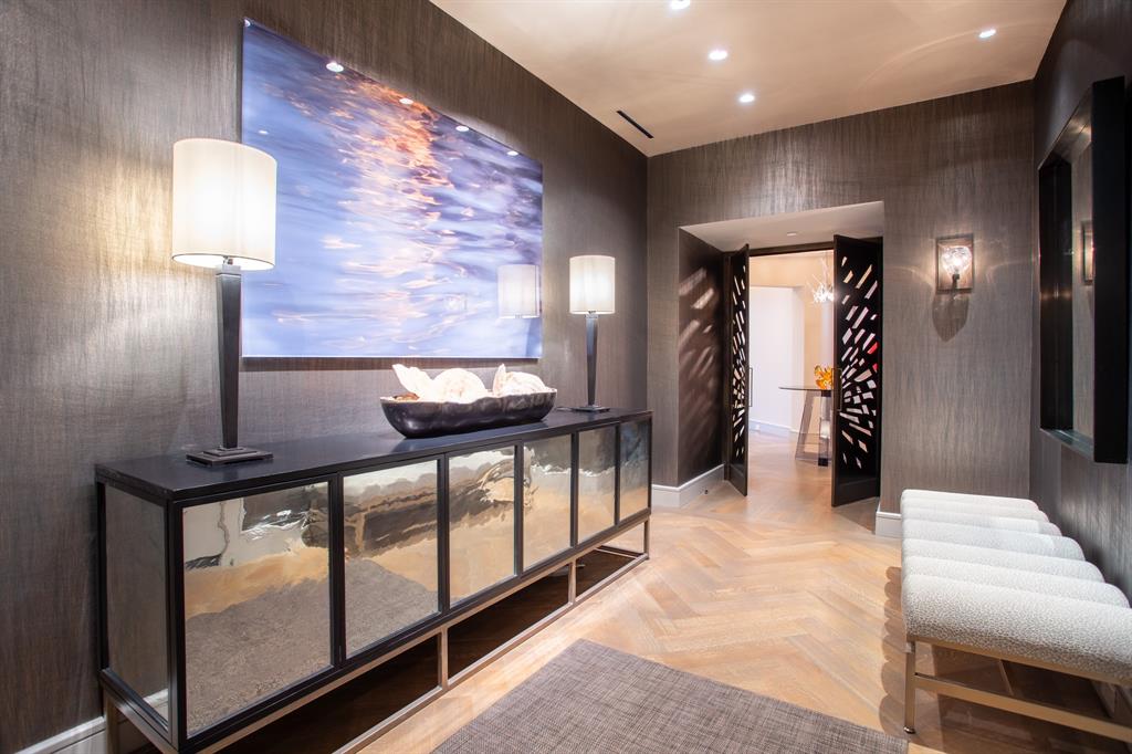 Fabulously finished bespoke Stoneleigh B+ plan has 3 bedrooms, 4.5 baths, 3 parking spaces, oak floors, 10 ft ceilings, 2 ventless fireplaces, 2 balconies, Smart home Lutron lighting & shades, sophisticated sound system. Direct-access elevator into a private foyer leading to a rotunda with custom designed metal doors and a domed ceiling. Interior designed by Sandy Zisman of Nine Interiors. Spectacular open living-dining-family room set against the backdrop of a large balcony with views of the Margaret Hunt Hill Bridge and downtown Dallas. Custom quartz and brass wall surround for television. Kitchen features book-matched quartzite over the range. The breakfast area boasts book-matched quartzite over a built-in hutch with a mirrored cabinet above. Appliances include a Wolf gas range, oven and steam oven, Scotsman Sonic ice maker, Sub-Zero 36” refrigerator and 36” freezer, Miele dishwasher, microwave, large walk-in pantry. Kitchen island has four bar stools and pendant lighting. Gorgeous onyx backlit powder room. Master suite features a balcony plus his and her baths, two very generous walk-in closets and signature rift white oak custom cabinets. Laundry room washer and dryer plus built-in cabinets and closet for a steamer. One guest suite with twin beds and ensuite bath also has access to the main balcony. The second guest suite with a king bed has access from the rotunda and private access from the main hallway.  5-star hotel amenities include concierge, valet, room service, fitness, resort-style pool, owner's lounge, theater, outdoor fireplaces & grills, a grand lawn, banquet room & catering kitchen. Uptown walkable to myriads of restaurants, entertainment venues and shops.