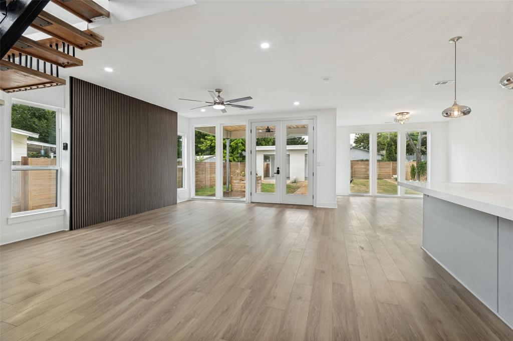 Beautifully remodeled and move-in ready, this exceptional home offers 3 bedrooms, 3 full bathrooms, and a spacious office that can serve as a formal dining room or be easily converted into a 4th bedroom. Designed with luxury and functionality in mind, the open-concept floor plan features a stunning floating staircase, hidden walk-in pantry, and en-suite bathroom for every bedroom. The chef-inspired kitchen is the heart of the home, showcasing a massive island, brand-new stainless steel appliances, gas cooktop, vent hood, custom cabinetry, and a hidden door leading to the walk-in pantry. The light-filled family room features a custom accent wall and flows seamlessly into the dining area, offering peaceful views of the expansive backyard. Upstairs, beautifully restored 100-year-old reclaimed wood flooring adds warmth, character, and timeless charm. The luxurious primary suite includes a spa-like bathroom with dual vanities, a separate walk-in shower, dramatic floor-to-ceiling tile accents, and a spacious walk-in closet. Enjoy outdoor living on the covered patio overlooking the large, grassy backyard—perfect for entertaining, family gatherings, or relaxing evenings. The property also includes a rear-entry 2-car carport with convenient alley access. Ideally located just 10 minutes from Downtown Dallas and only 5 minutes from the vibrant Bishop Arts District, this home offers easy access to some of the city's best dining, shopping, and entertainment while providing the comfort of a beautifully updated residence.