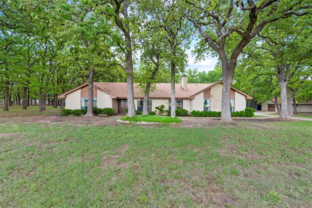 One of a kind property in the heart of Springtown! 9 beautiful acres with a one story home, separate shop, and barn with tons of mature trees and a pond in the back. This one story brick home features two bedrooms with a full bath on one side of the home, with the master suite on the opposite end. Breathtaking views of the land can be seen from the large covered back patio. The climate controlled shop has the flexibility to be made into a mother in law suite with all utilities currently connected. The barn provides tons of space for equipment storage and room for any livestock. The close proximity to the downtown square makes this location ideal for all!  You can enjoy the privacy and peacefulness of country living without compromising convenience. This property is gated and fenced and offers a great Ag exempt homestead with plenty of room for growth and expansion if desired.